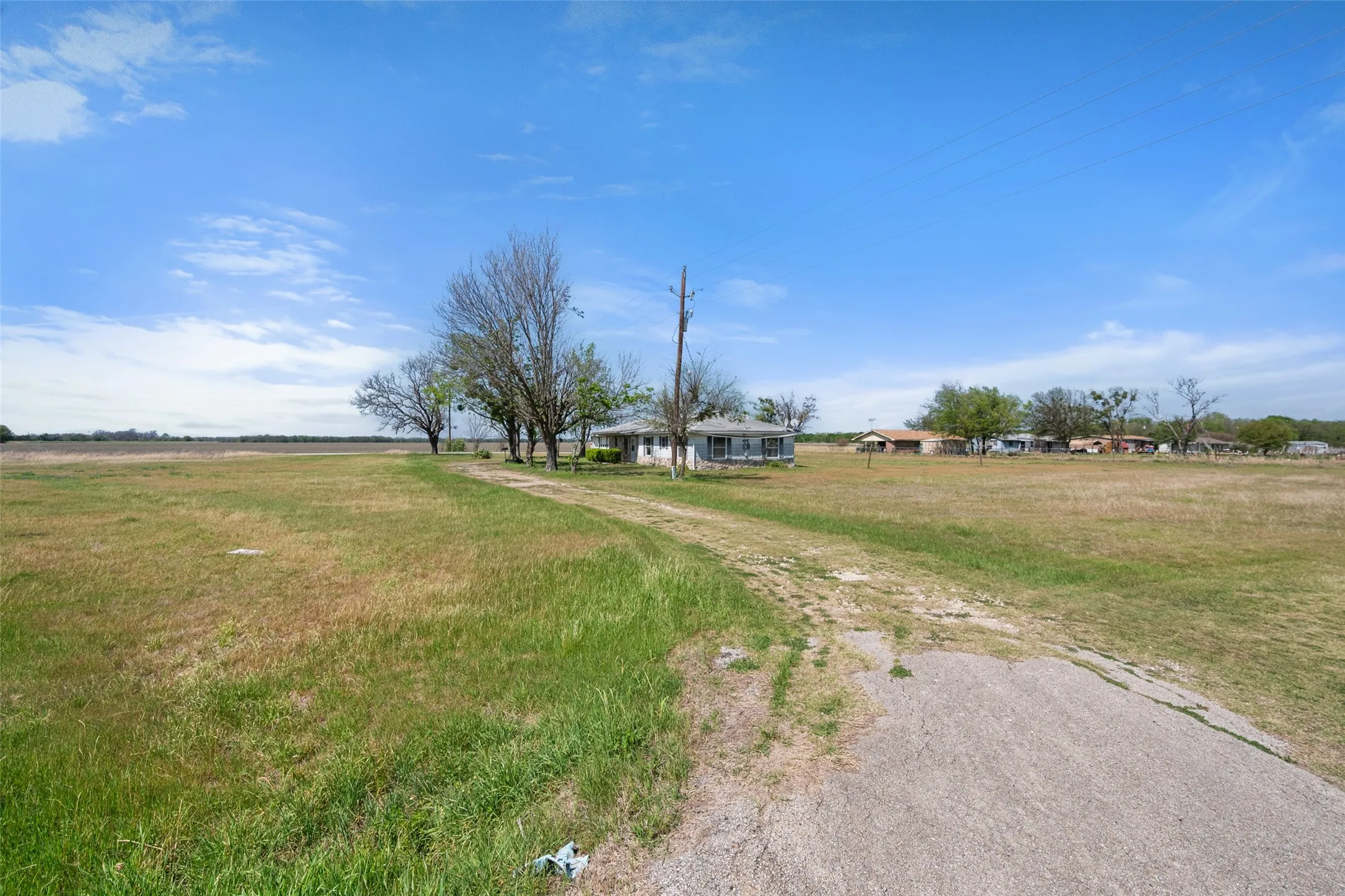 View of grassy yard featuring driveway and a rural view
