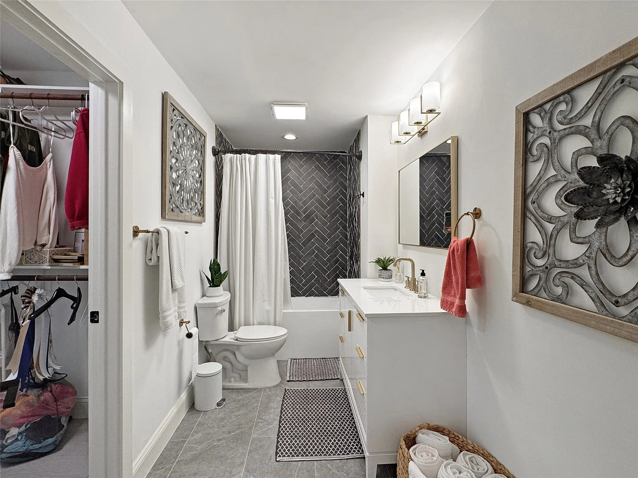 Bathroom featuring vanity, a spacious closet, shower / bath combo with shower curtain, and light tile patterned flooring