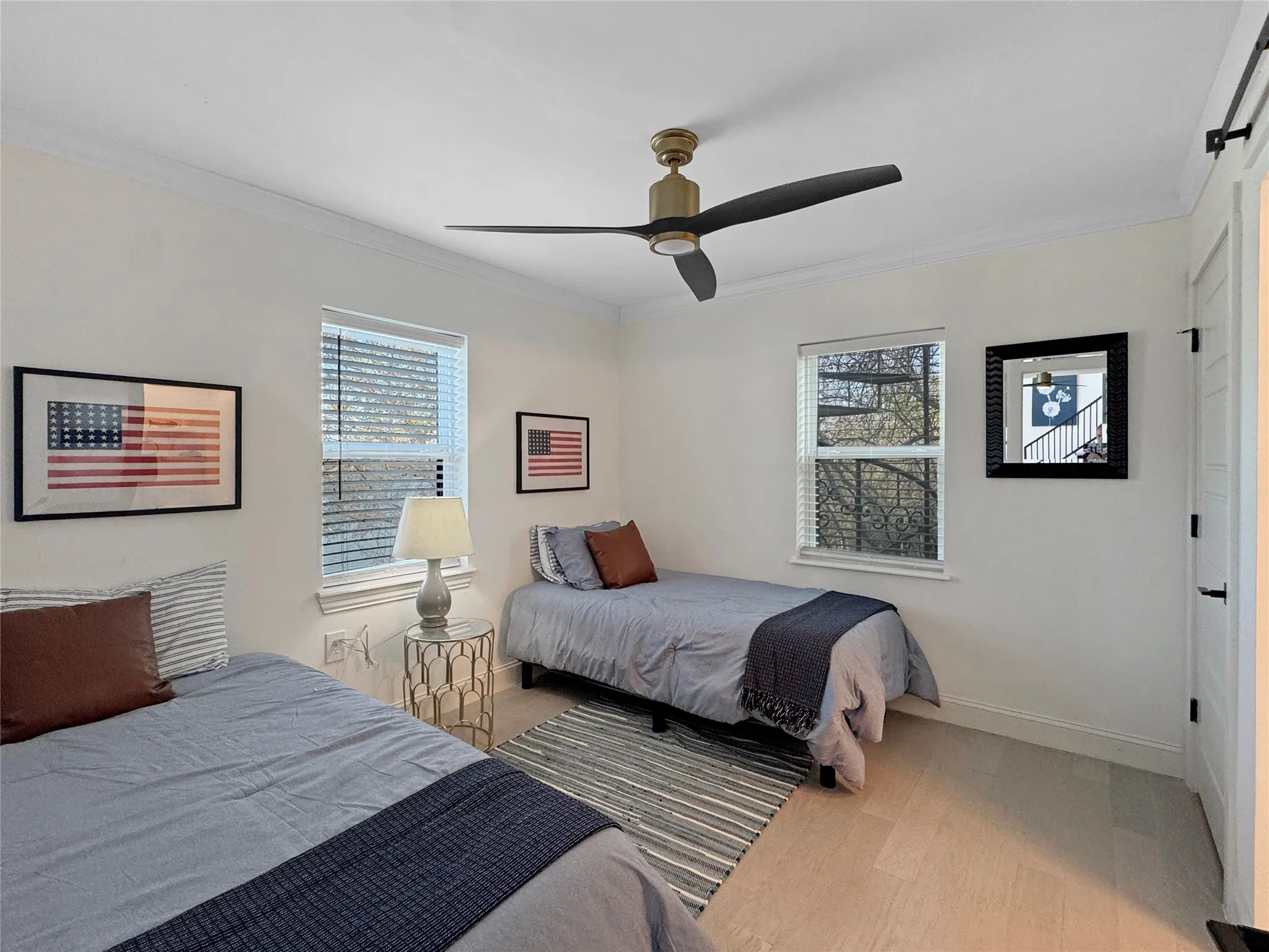 Bedroom featuring ornamental molding, light wood-style floors, and a ceiling fan