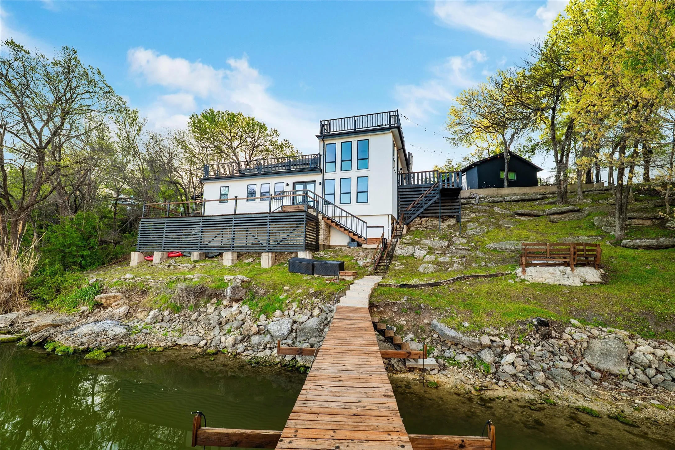 Rear view of property with stairway and a deck with water view