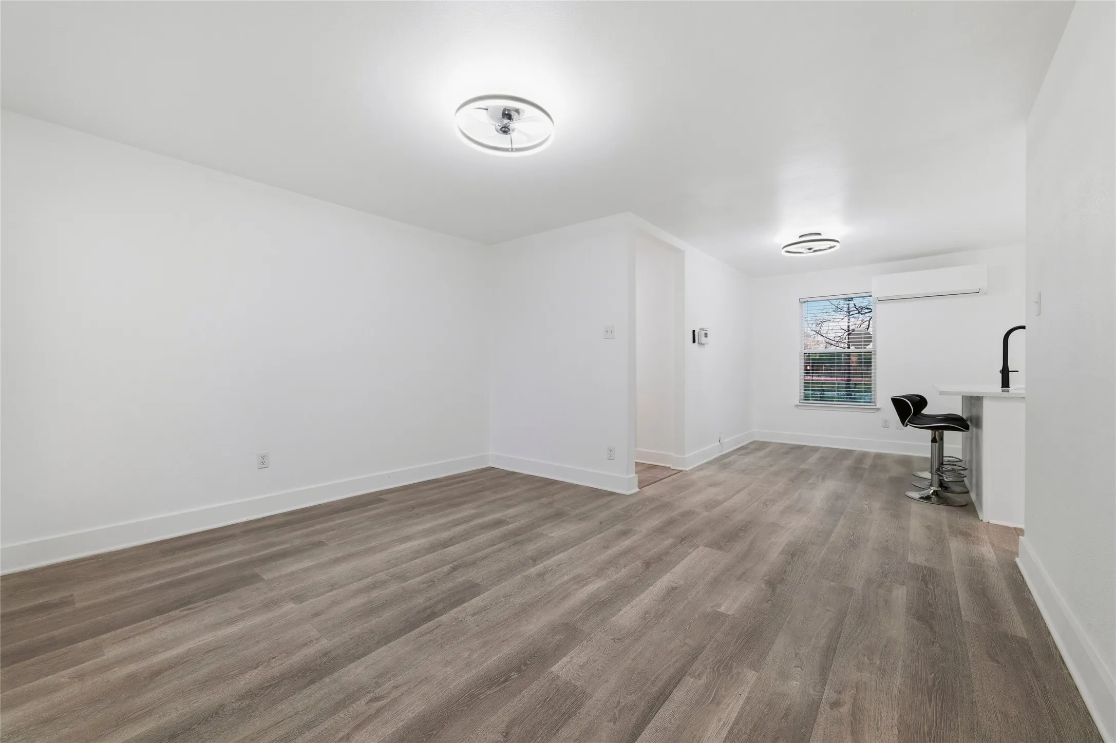 Additional living space featuring dark wood-style flooring and a wall mounted mini split