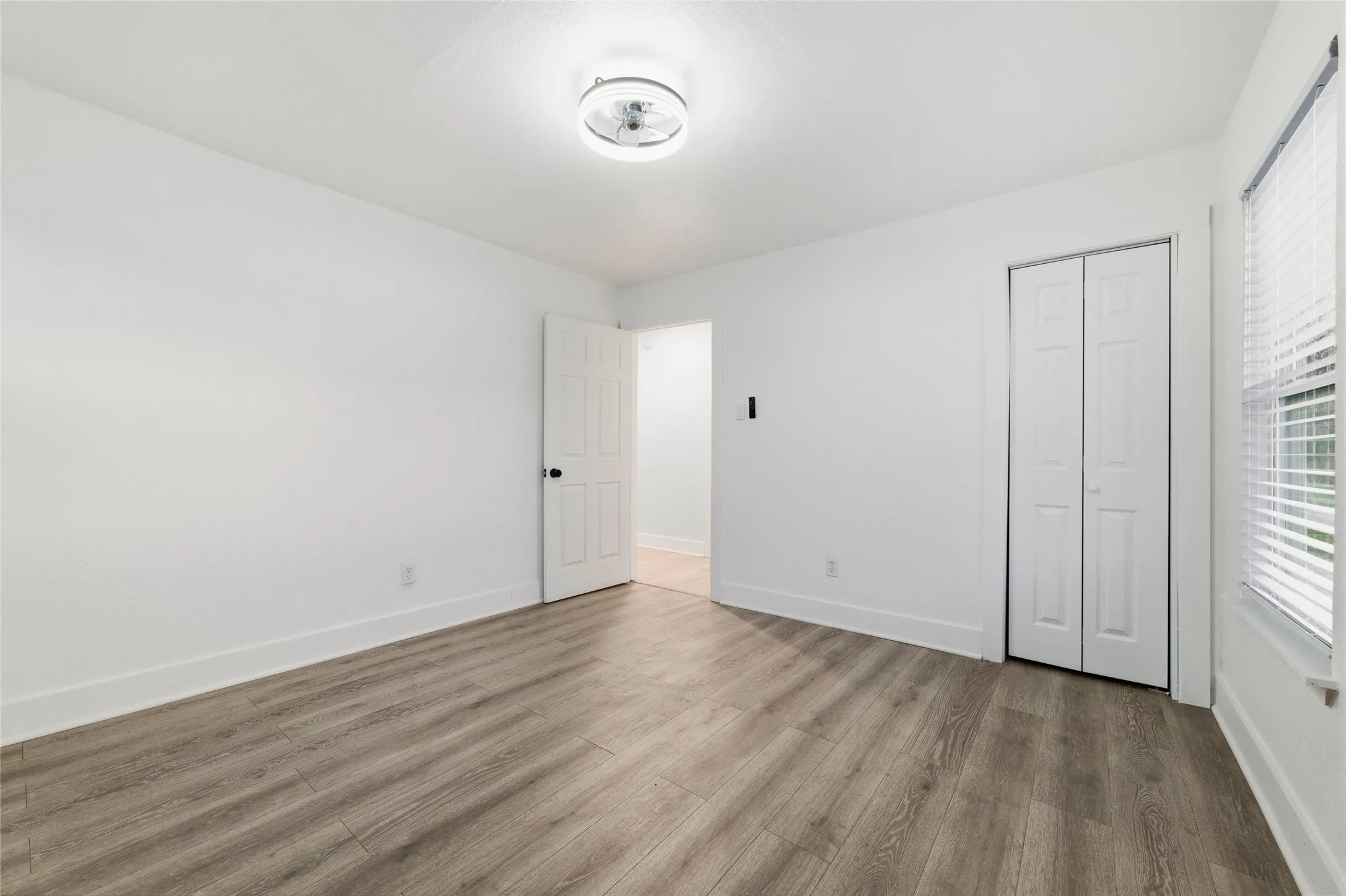 Unfurnished bedroom with wood finished floors and a closet