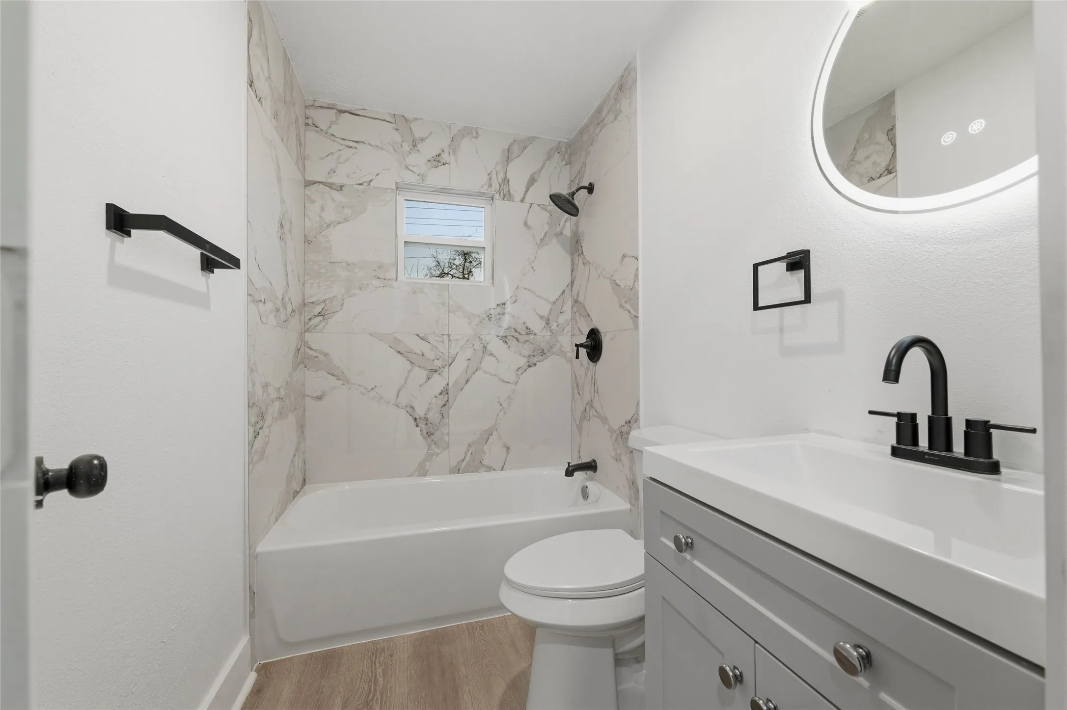 Bathroom with vanity, shower / bathtub combination, and light wood finished floors