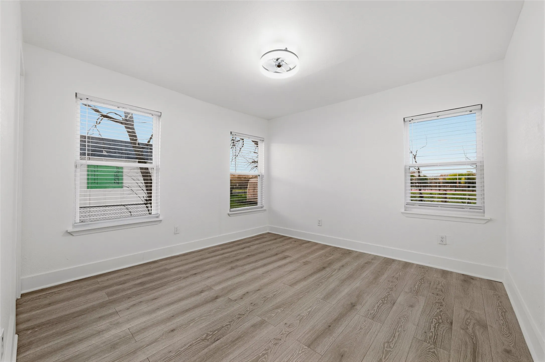 Unfurnished room with light wood-type flooring and healthy amount of natural light