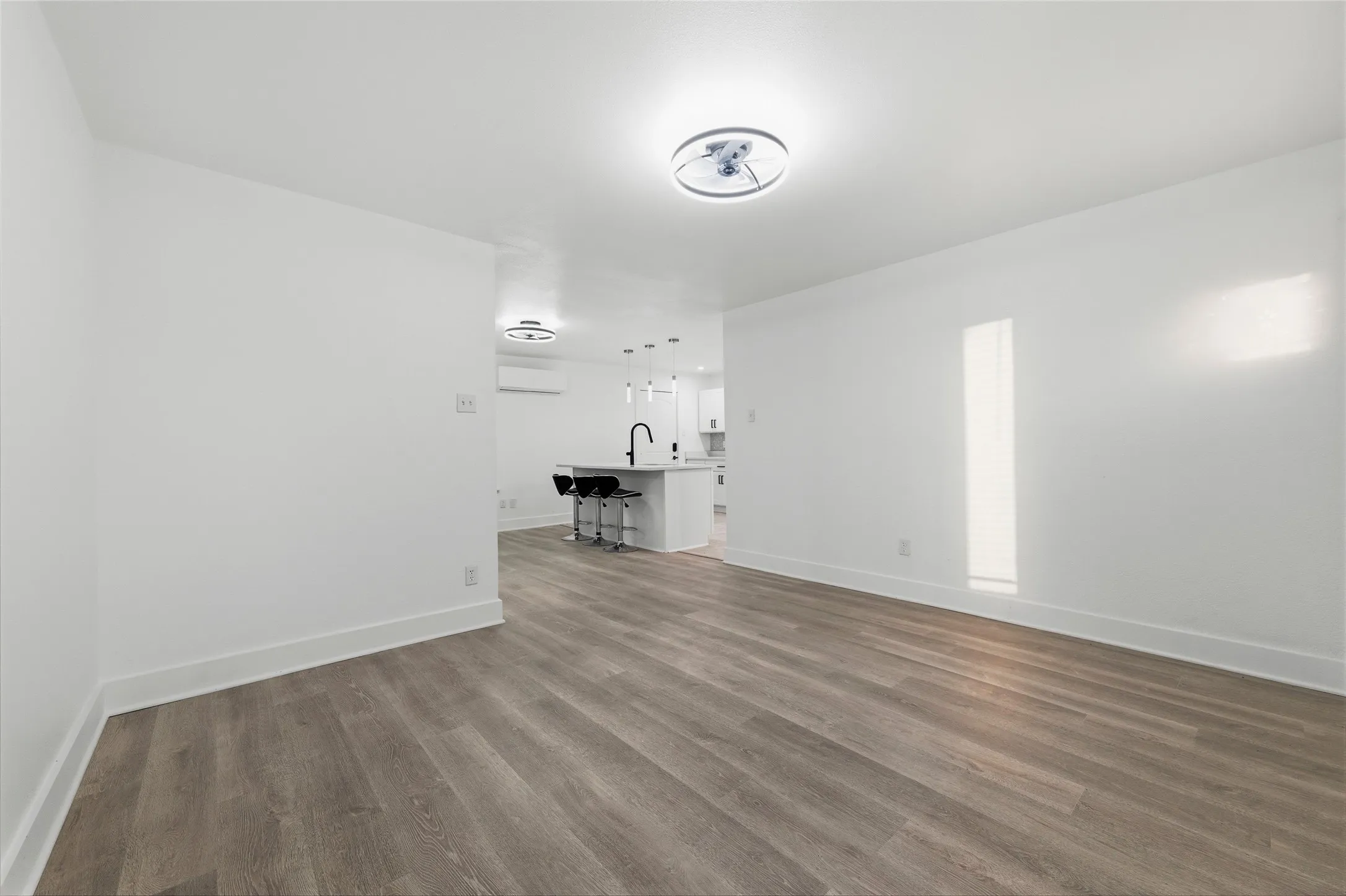 Unfurnished living room with dark wood-type flooring and baseboards