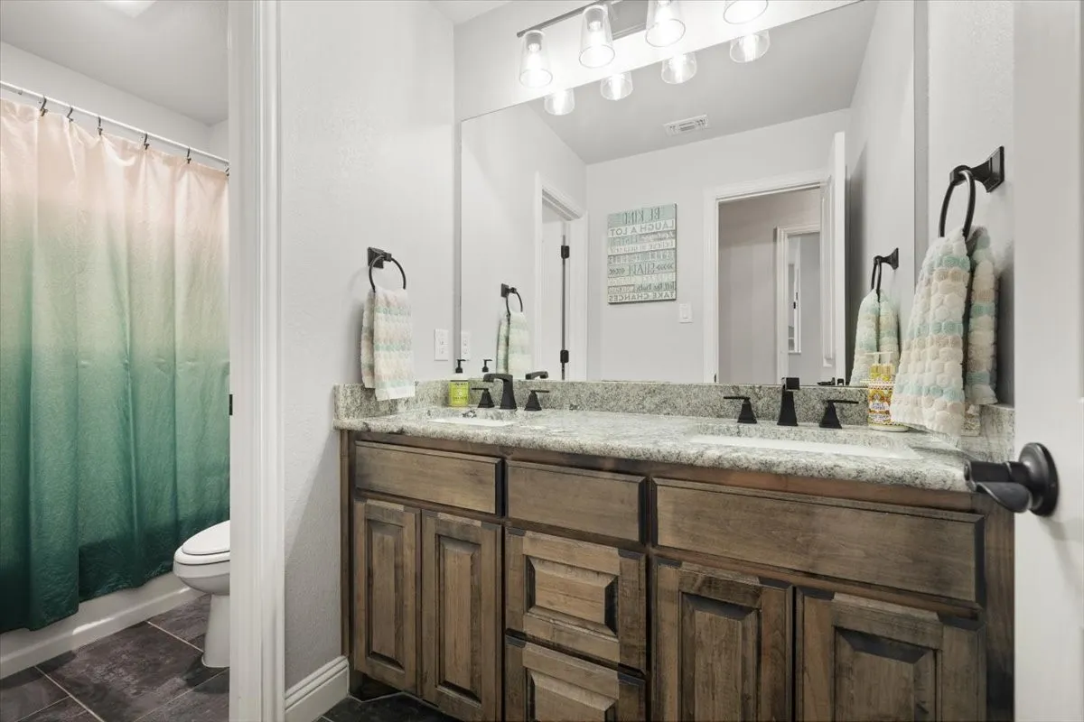 Full bathroom featuring double vanity and shower / tub combo with curtain