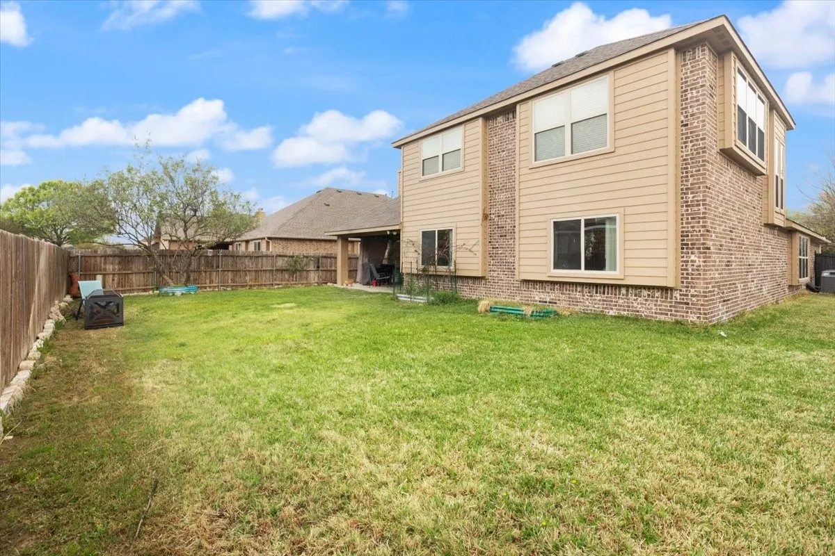 Rear view of property with a patio, brick siding, and a fenced backyard