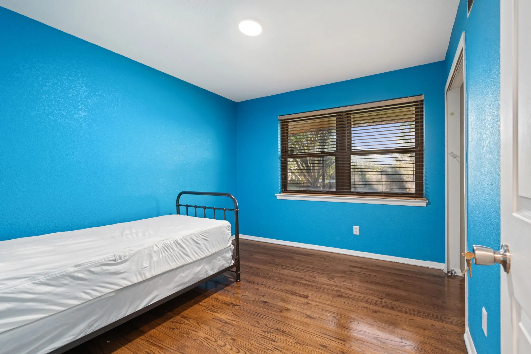 Bedroom featuring dark wood-type flooring and baseboards