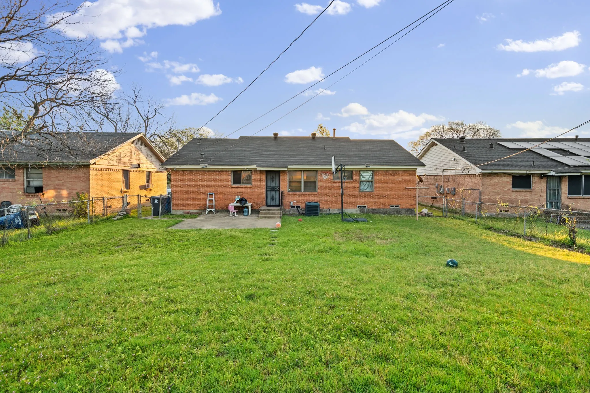 Rear view of property featuring a patio area, a fenced backyard, and brick siding