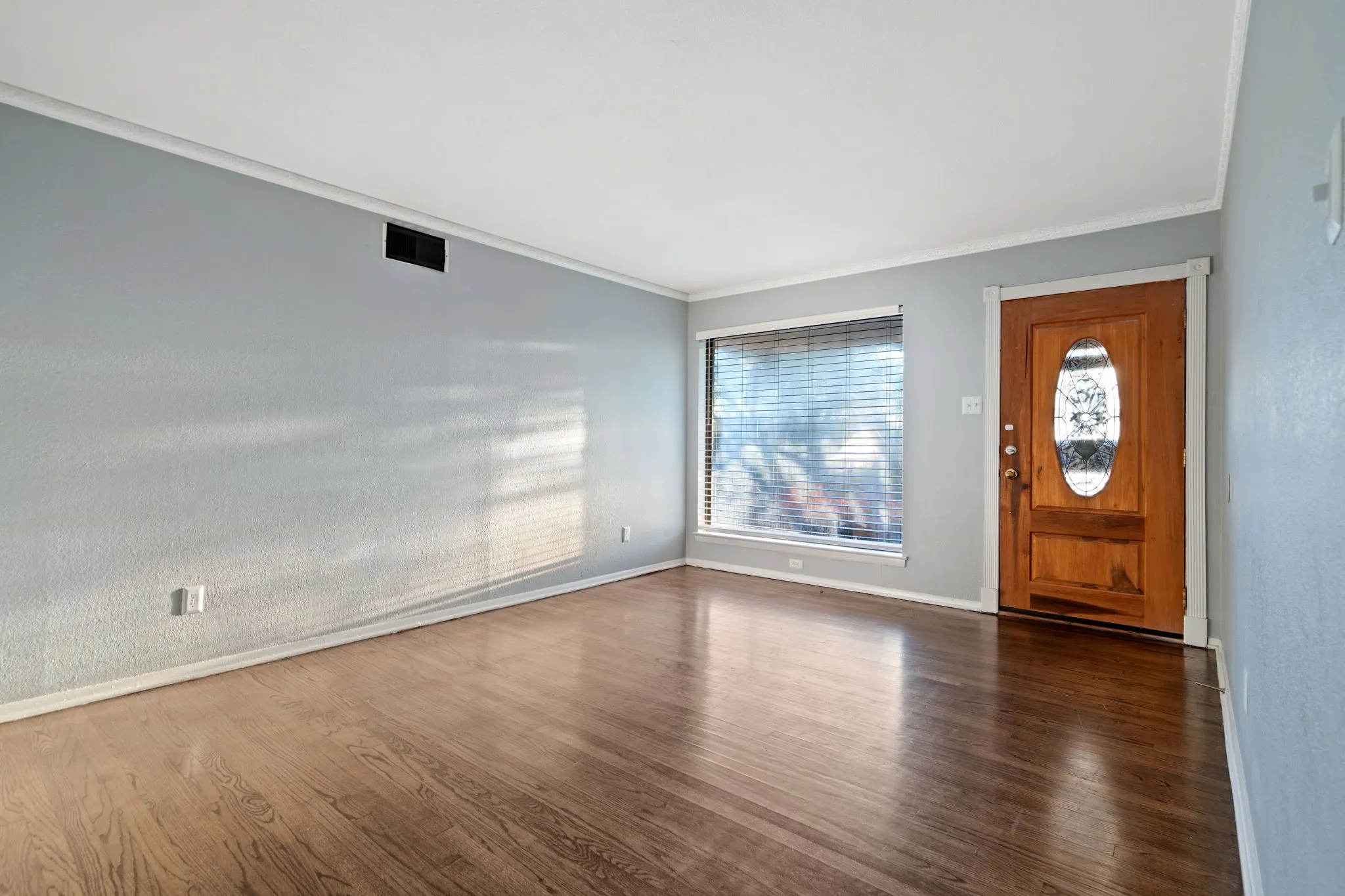 Foyer featuring dark wood-style floors and ornamental molding