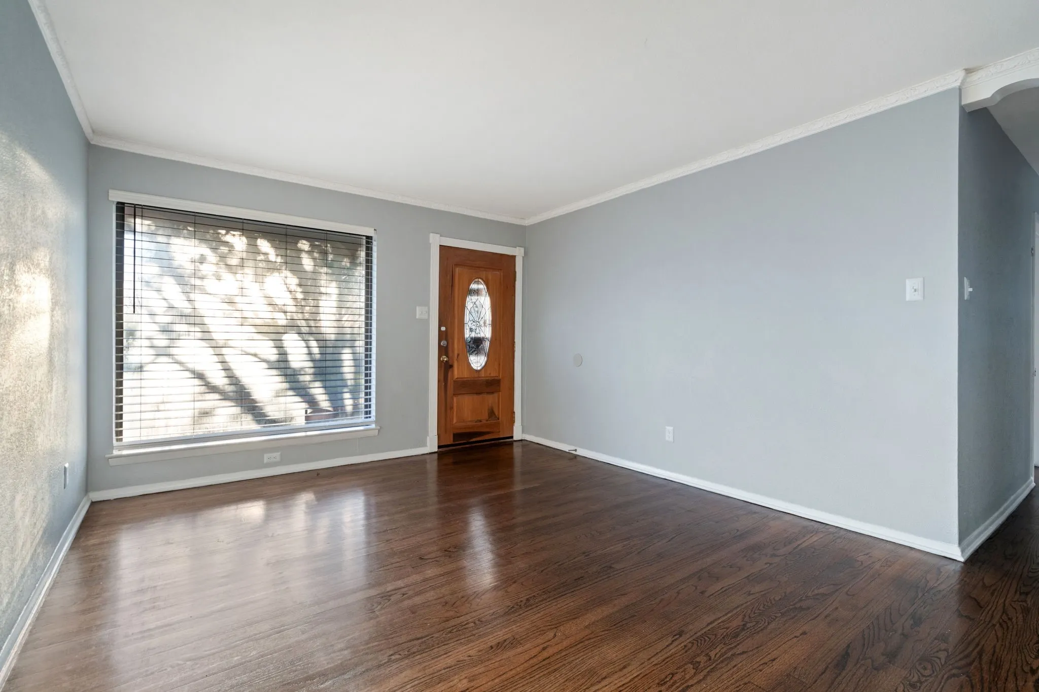 Entrance foyer with dark wood-style flooring and crown molding