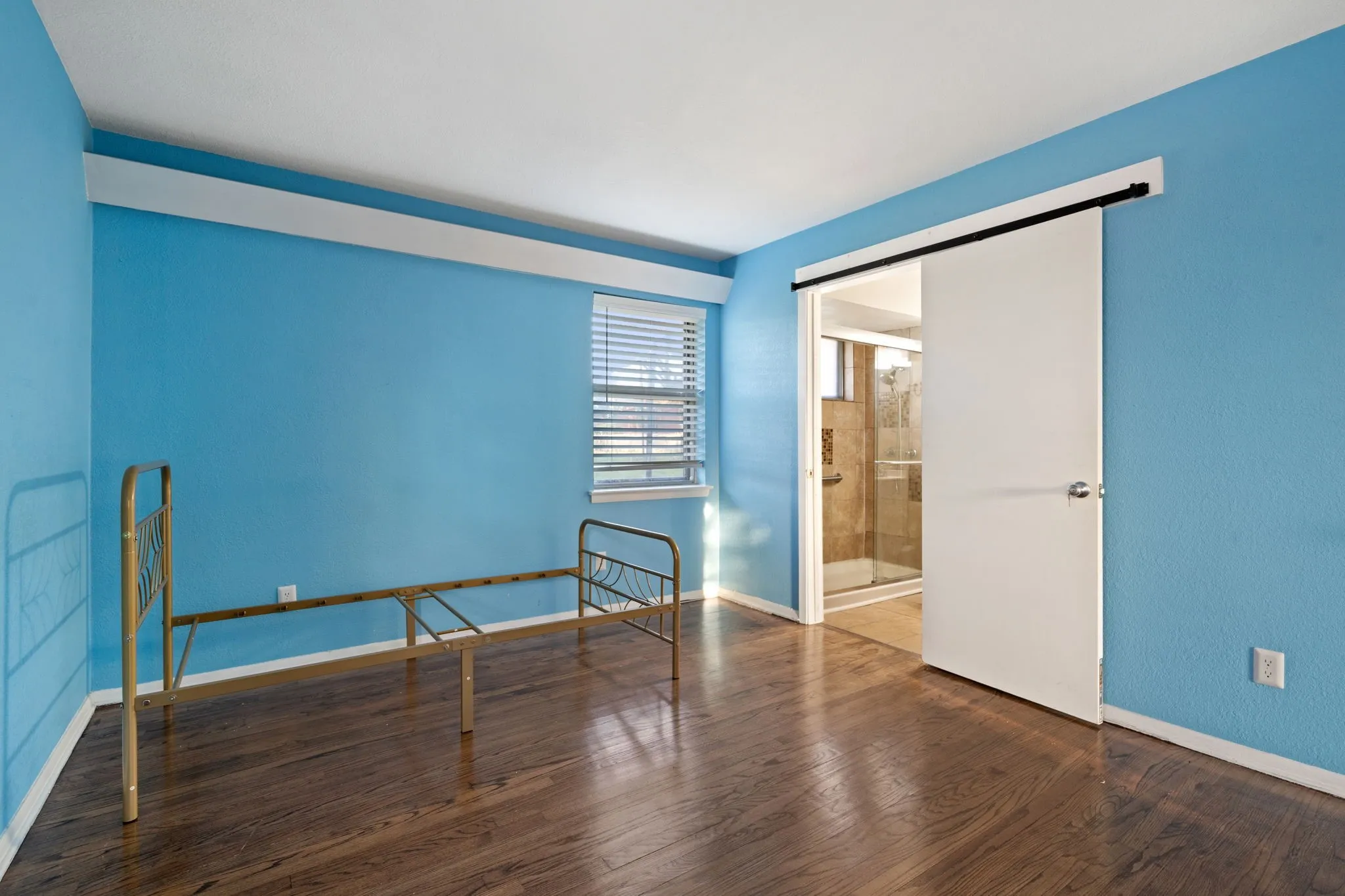 Unfurnished bedroom with dark wood-type flooring and ensuite bathroom