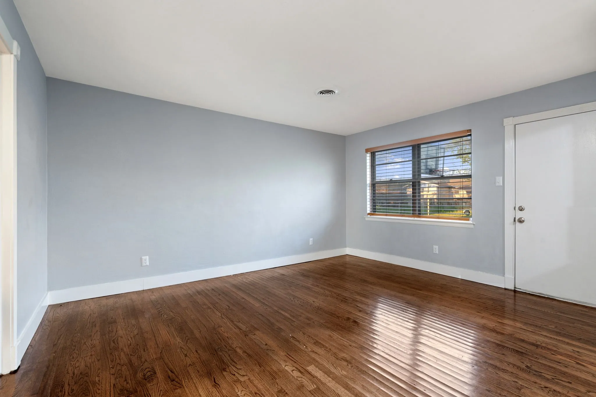 Unfurnished room featuring dark wood finished floors and baseboards
