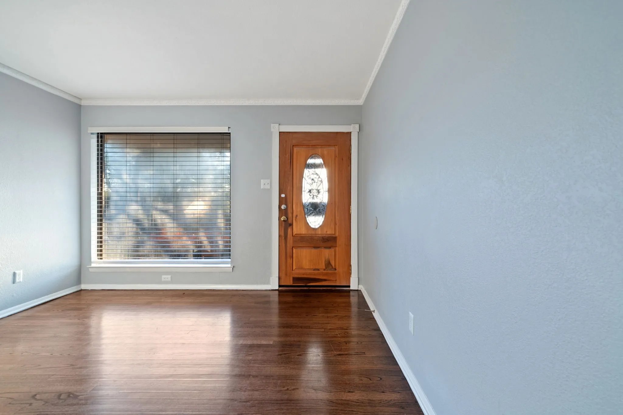 Entrance foyer with dark wood-type flooring and crown molding