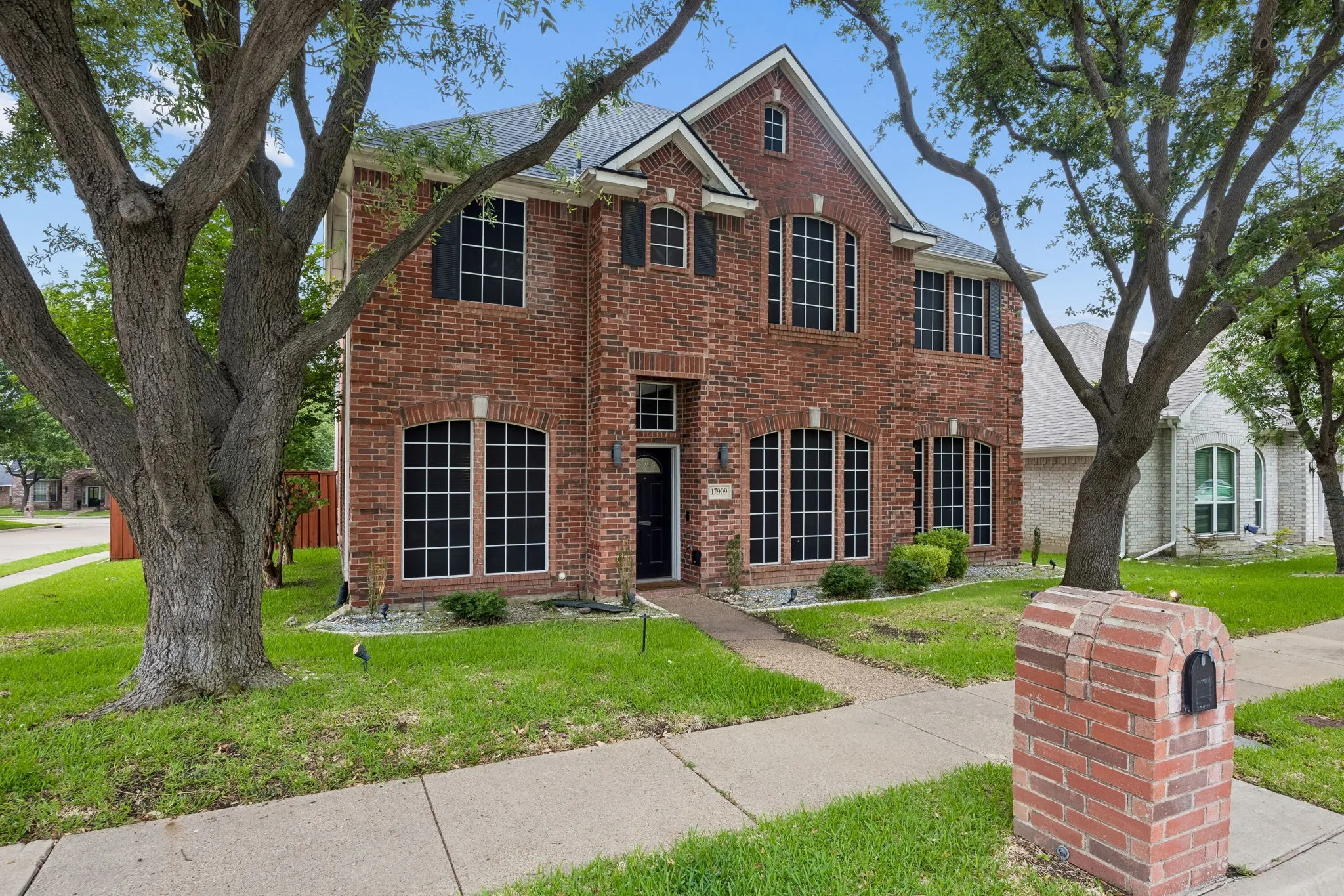 Two-story brick exterior featuring multiple arched windows with dark shutters