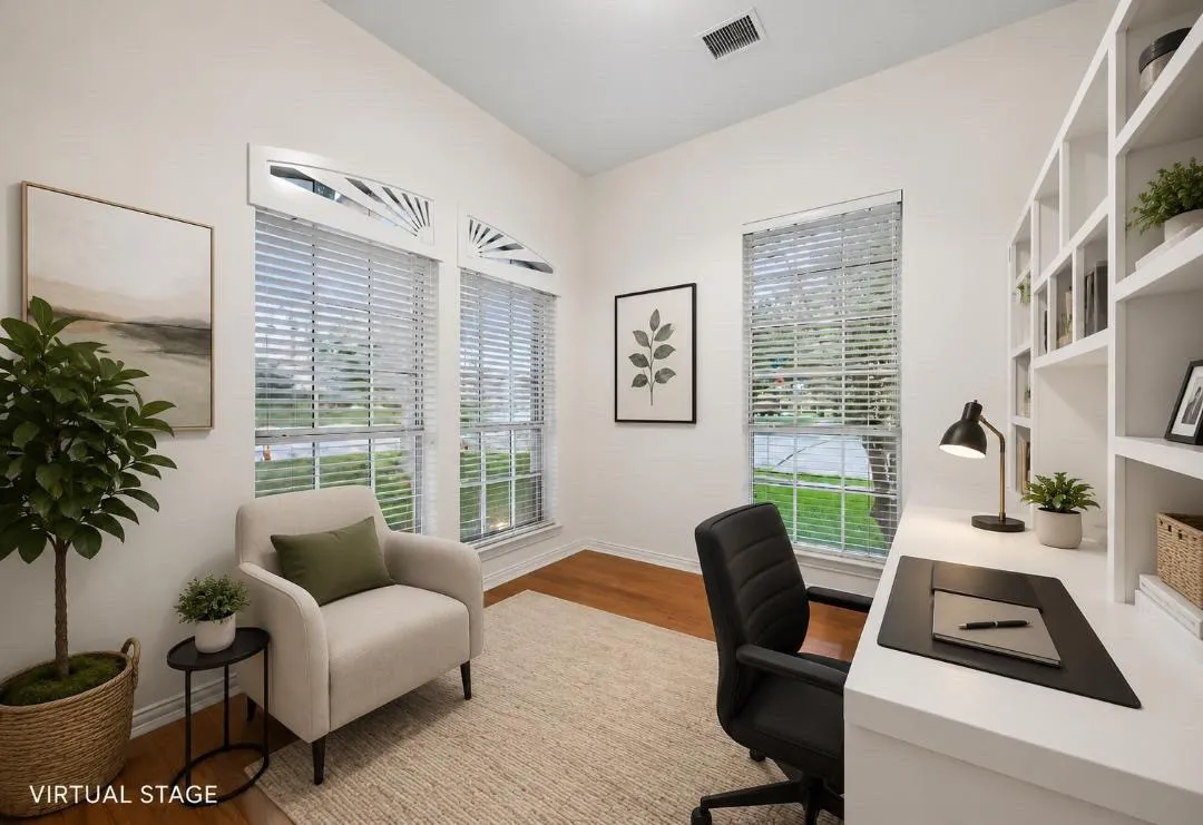 Bright interior room featuring vaulted ceilings, multiple windows with decorative arch transom accents, wood-finish flooring, and a built-in shelving unit