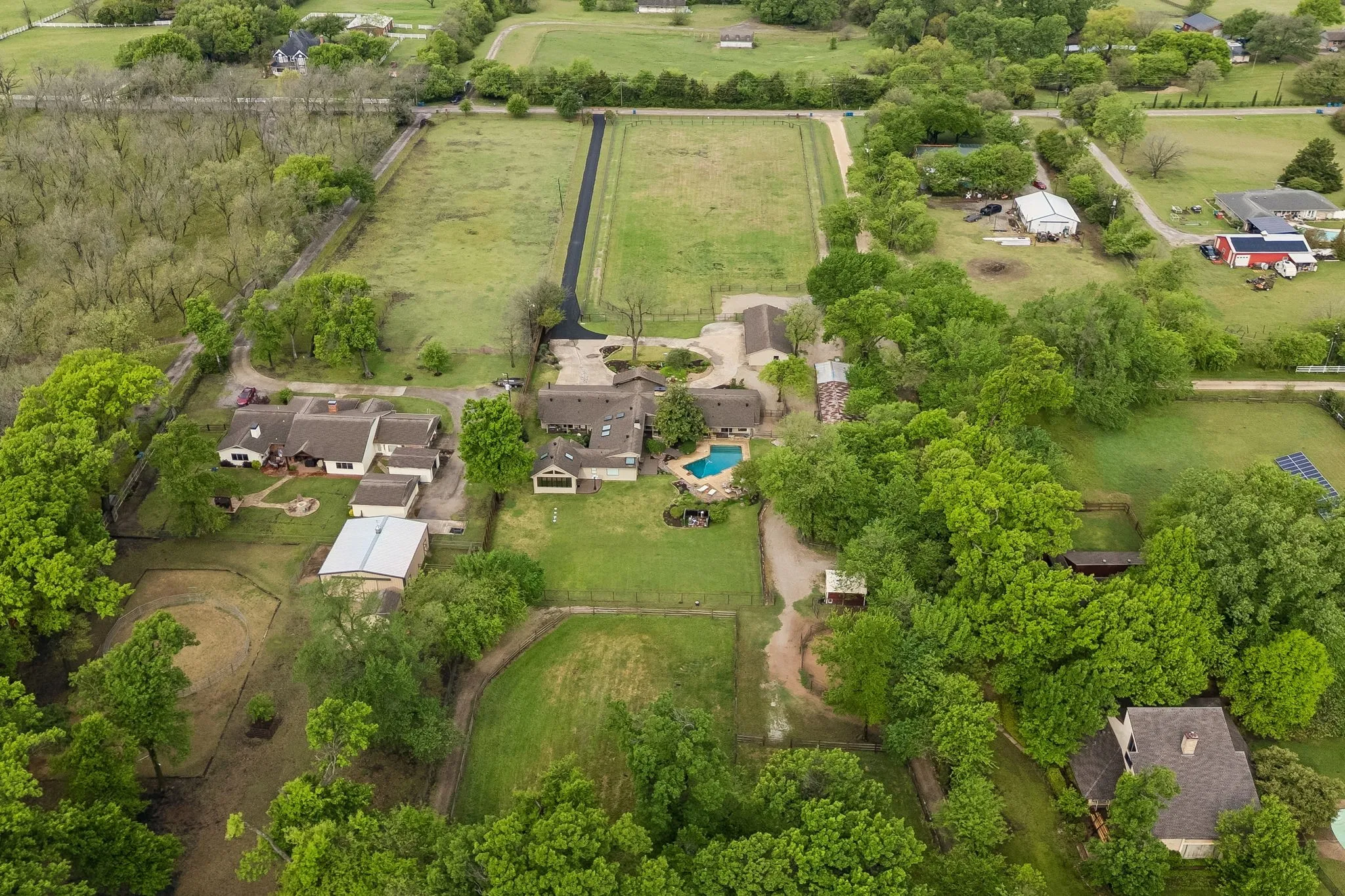 Aerial from the rear of the property highlighting pool and extensive yard completely separated from the horse pastures