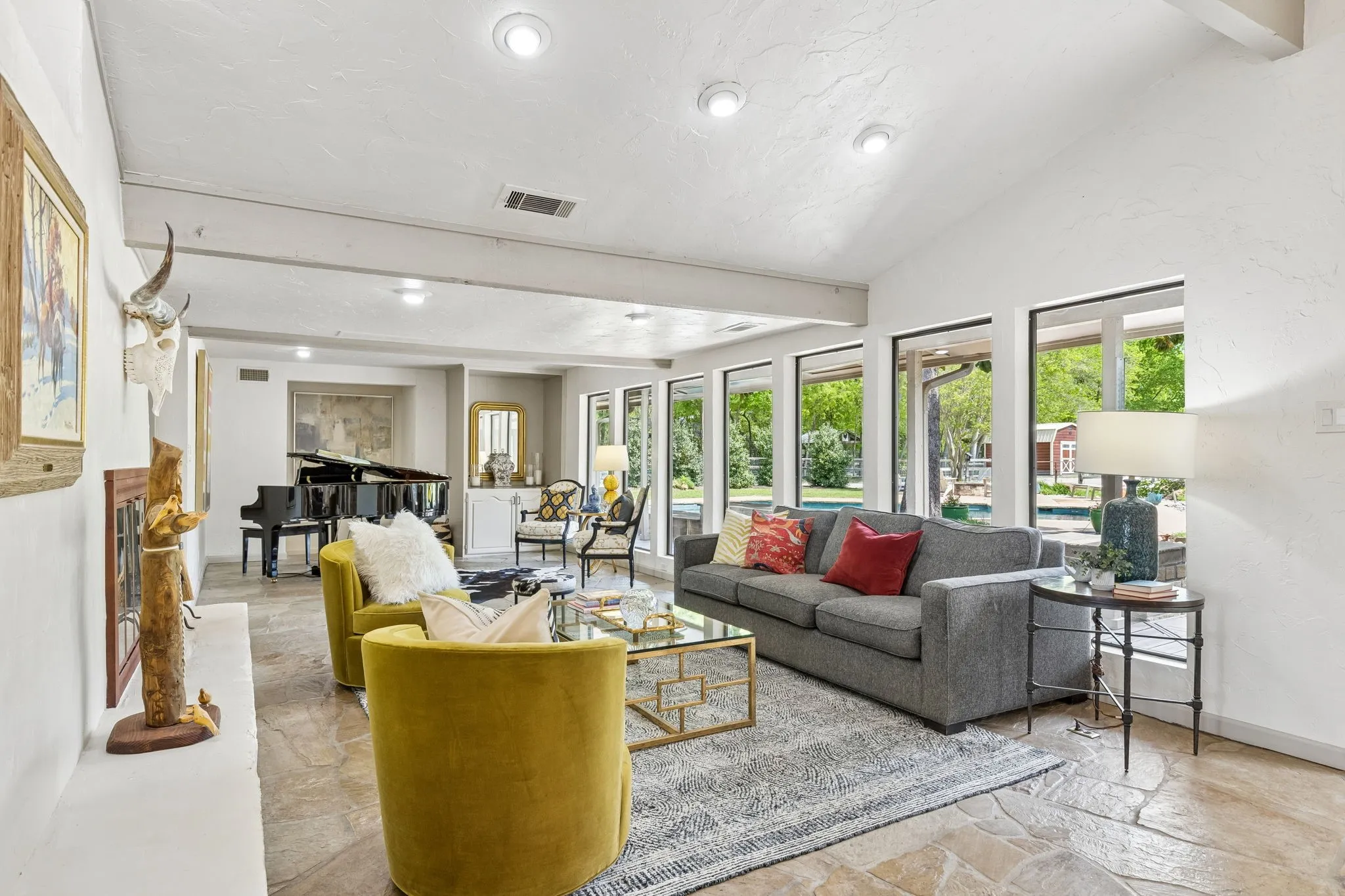 Family room with a wall of windows overlooking the pool, spa and fire pit.   It the back you will see the red barn or she-shed.