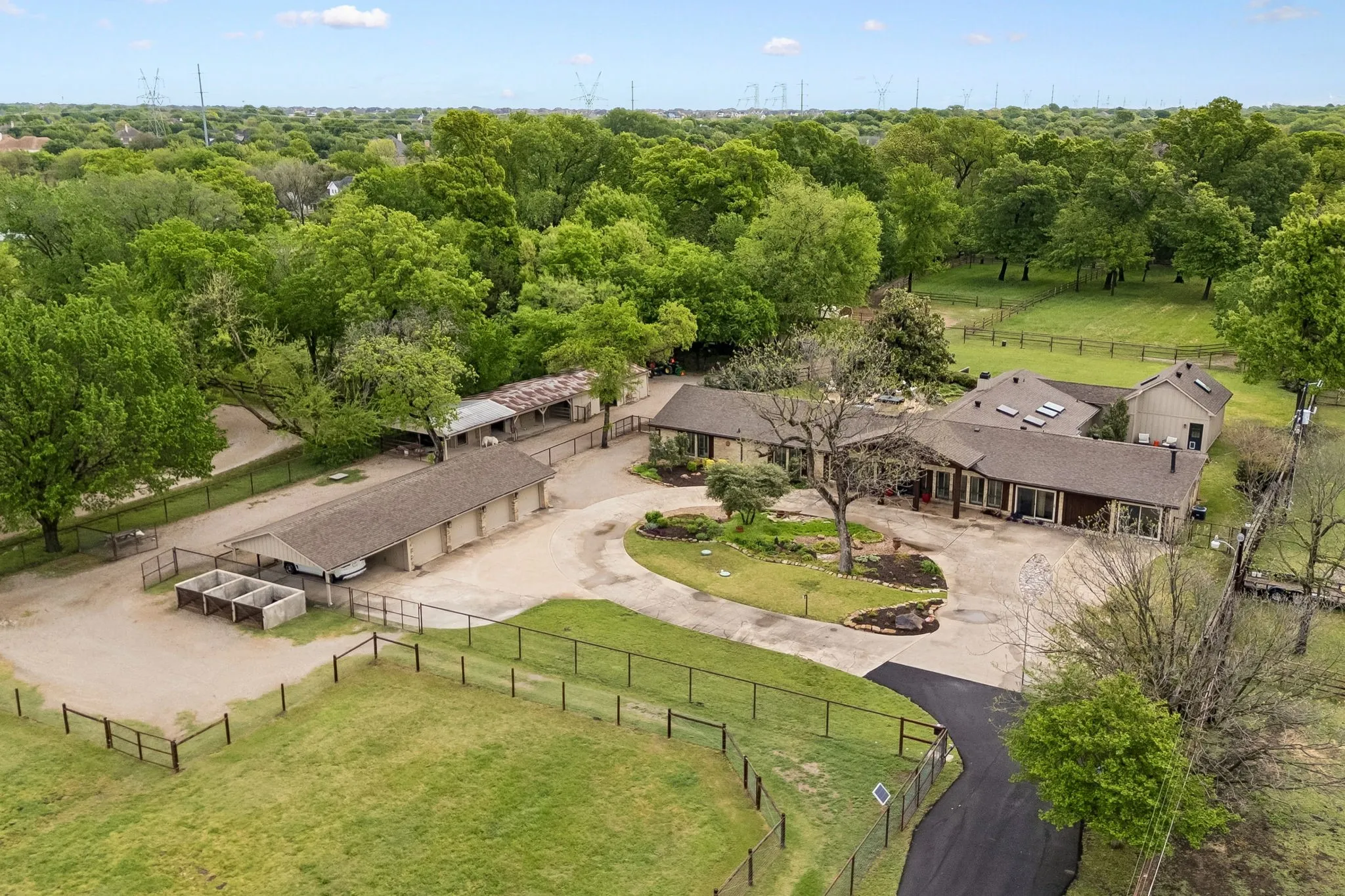 Aerial view of home with  4 car detached insulated garage, additional carport, composting station,  horse barn 1 of 3 pastures