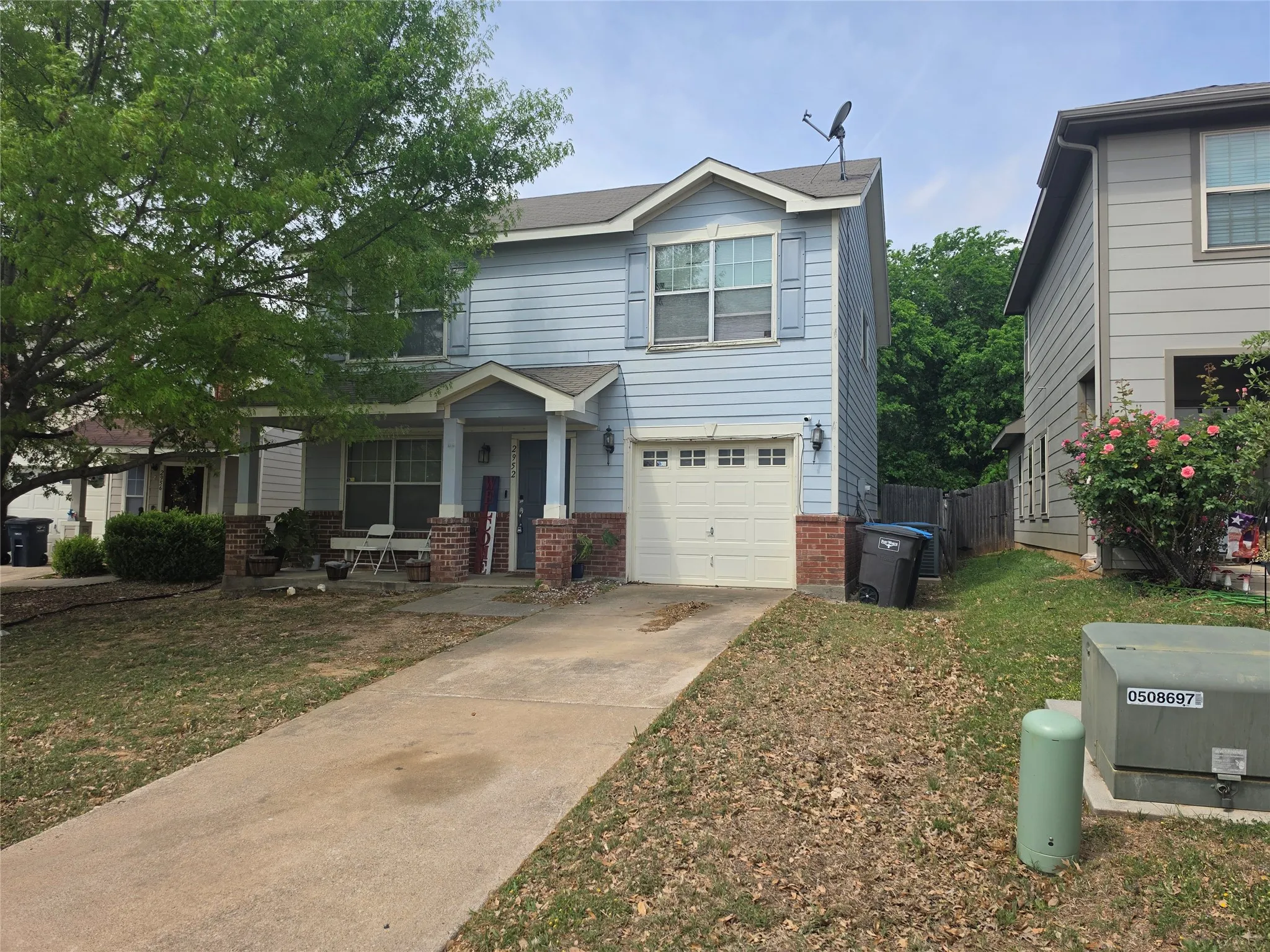 View of front of home with a garage, brick siding, driveway, and a front yard