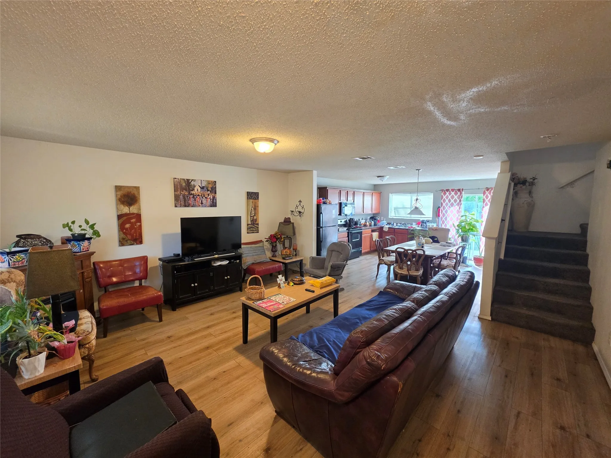 Living room featuring light wood finished floors and a textured ceiling