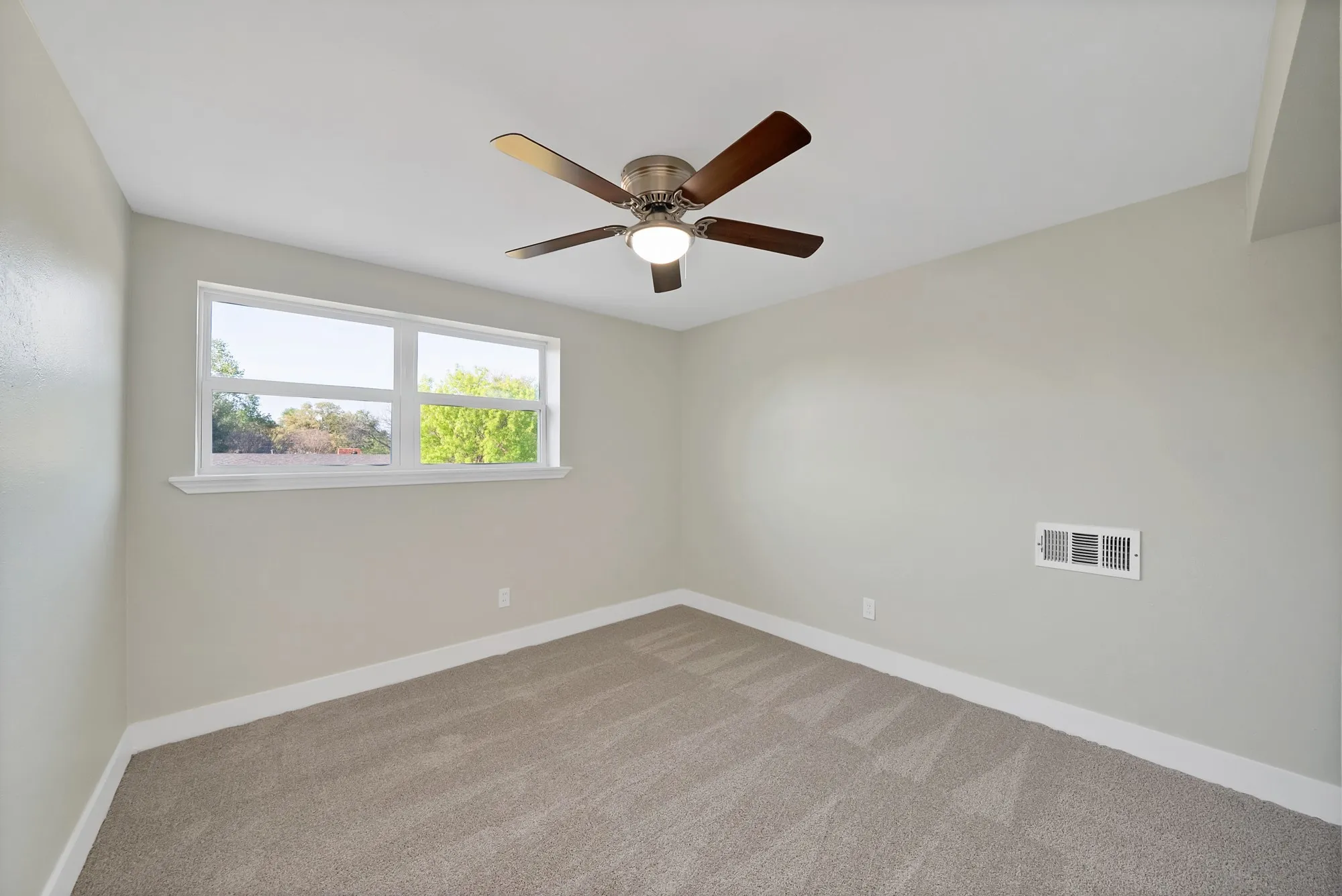Carpeted empty room with baseboards and ceiling fan