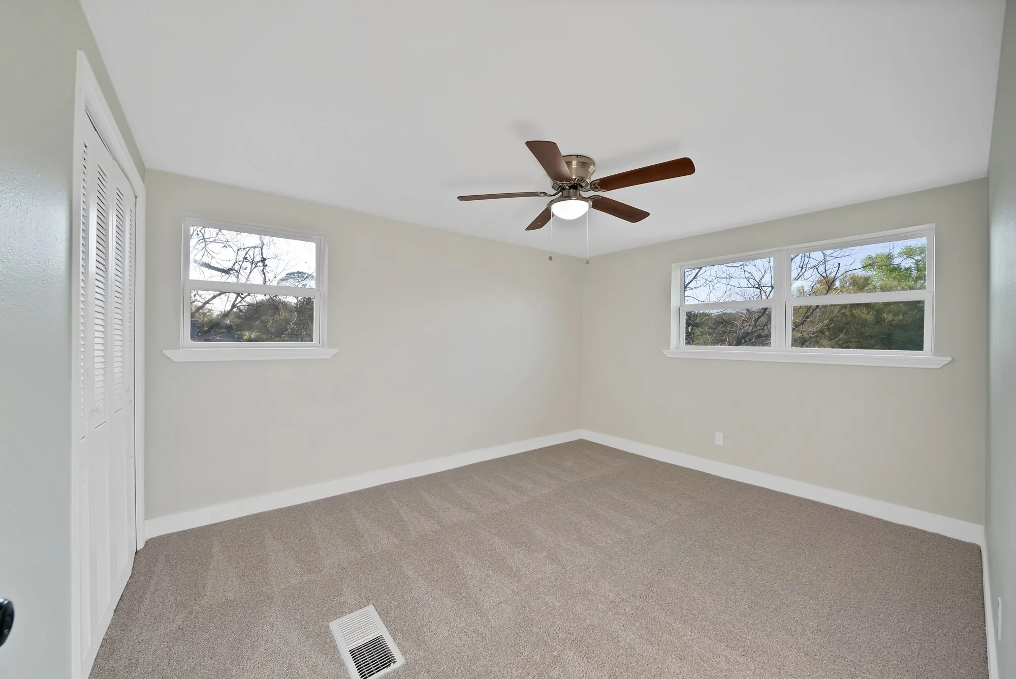 Unfurnished bedroom featuring a closet, carpet floors, and ceiling fan
