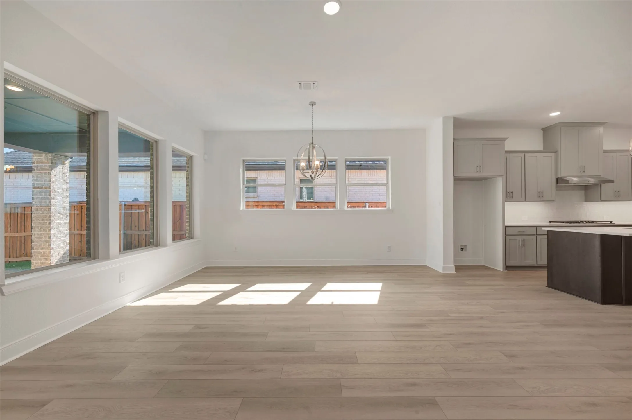 Open concept living area featuring light wood-finish flooring, a contemporary chandelier, and recessed lighting
