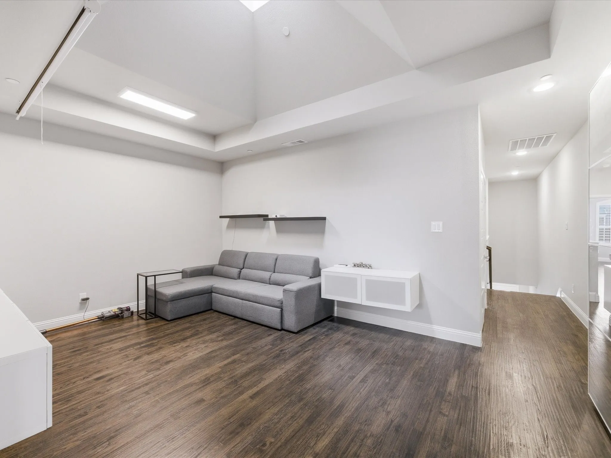 Living area featuring dark wood finished floors, recessed lighting, and a raised ceiling
