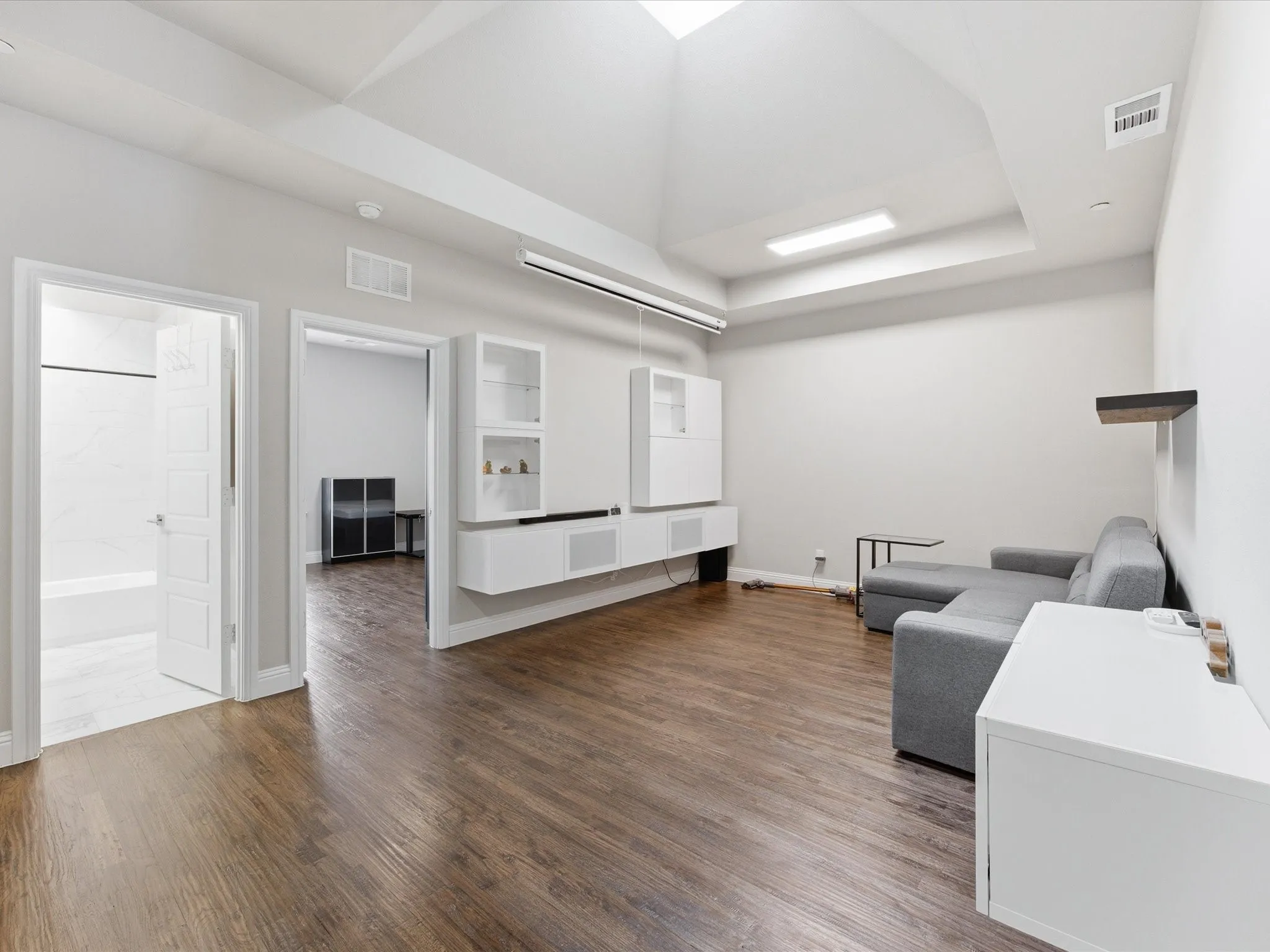 Living area featuring dark wood finished floors, recessed lighting, and a raised ceiling