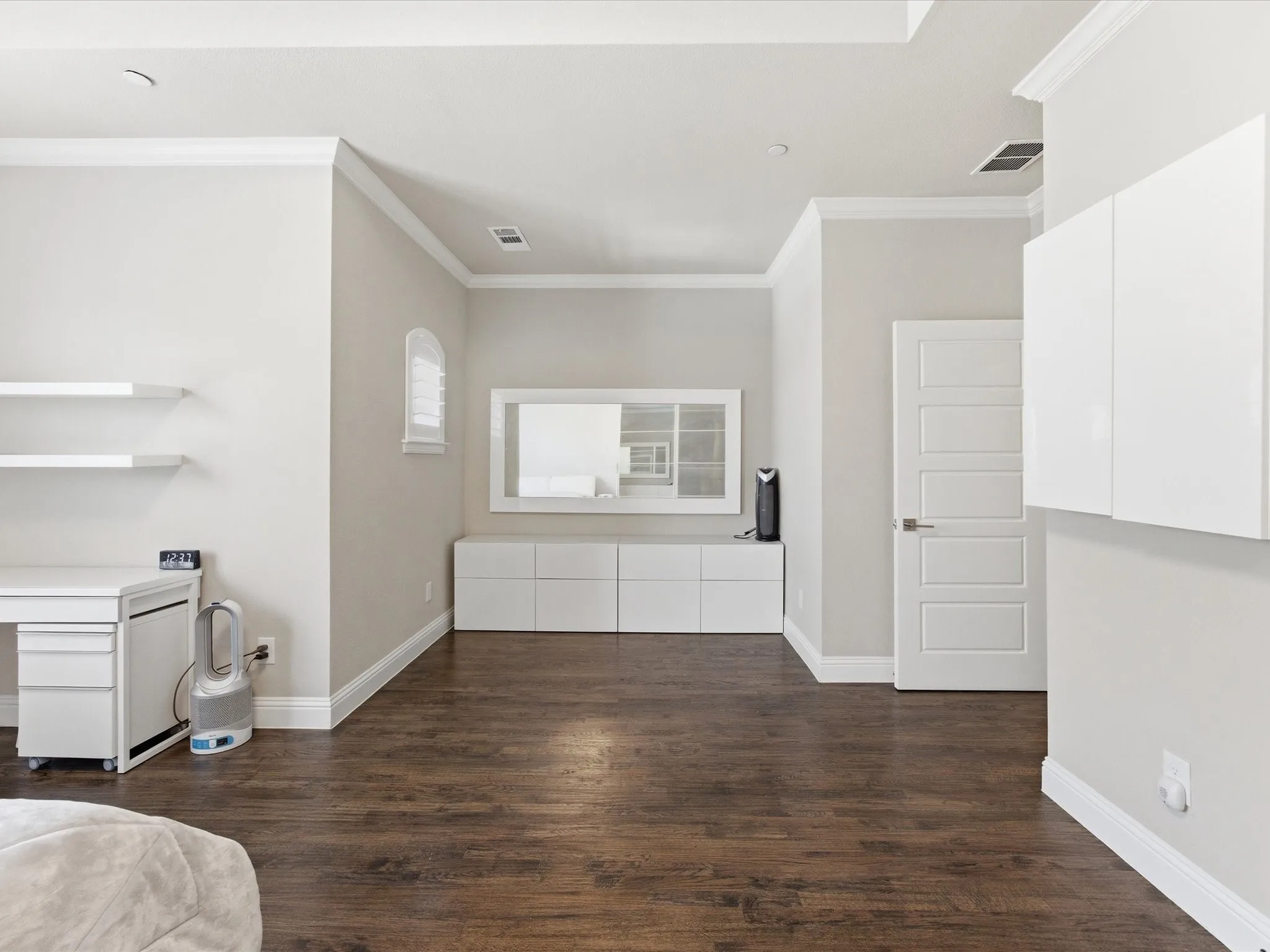 Primary Bedroom with dark wood-type flooring, a tray ceiling, and ornamental molding
