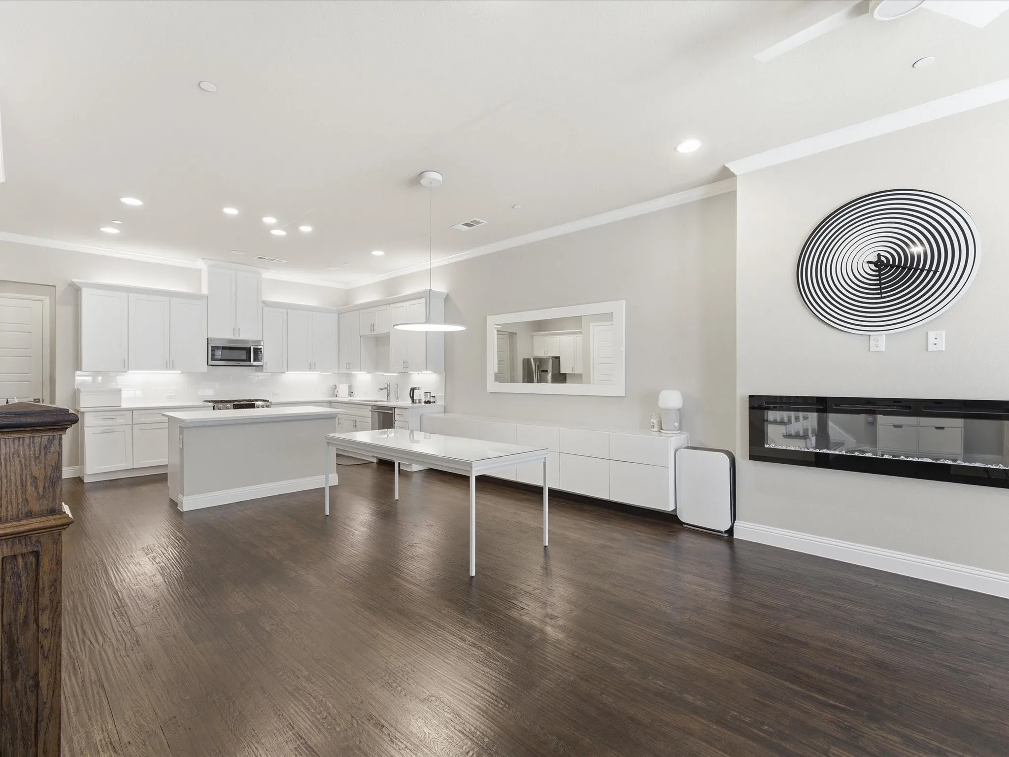 Kitchen with a center island, white cabinetry, light countertops, ornamental molding, and dark wood-style floors