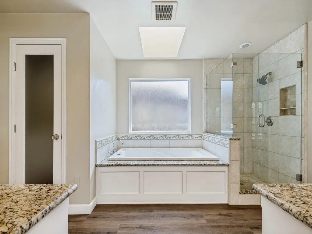Primary Bathroom with vanity, a shower stall, a bath, and dark wood-type flooring