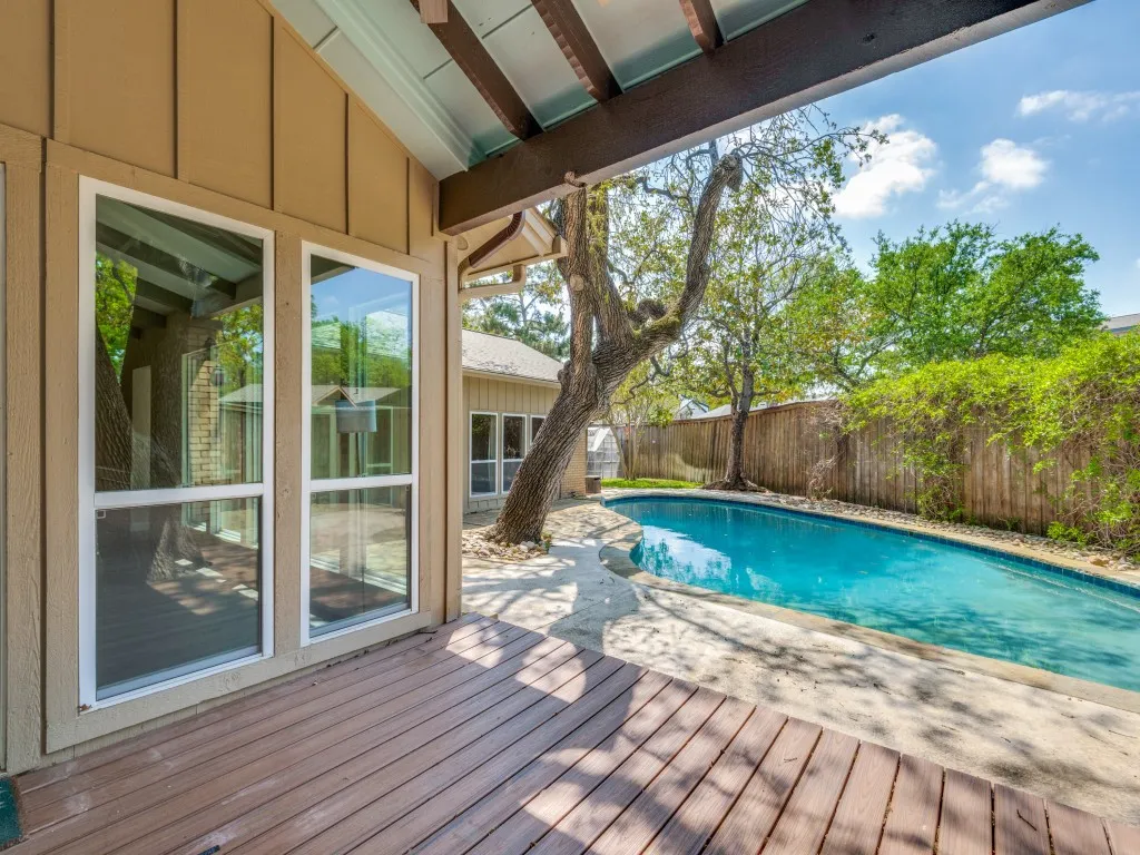 View of swimming pool with a fenced backyard, a deck, and patio surround