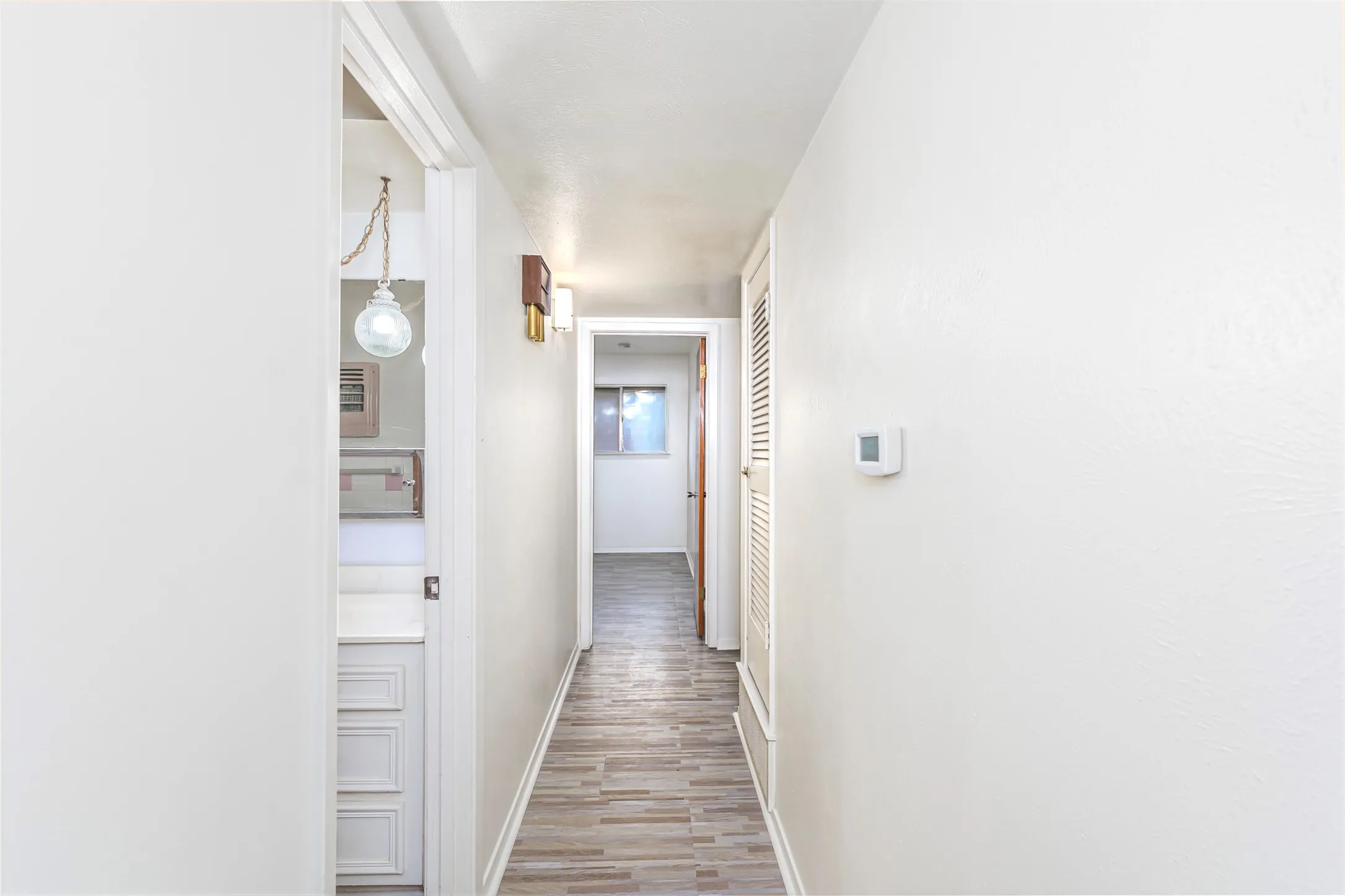 Corridor with baseboards and light wood-type flooring
