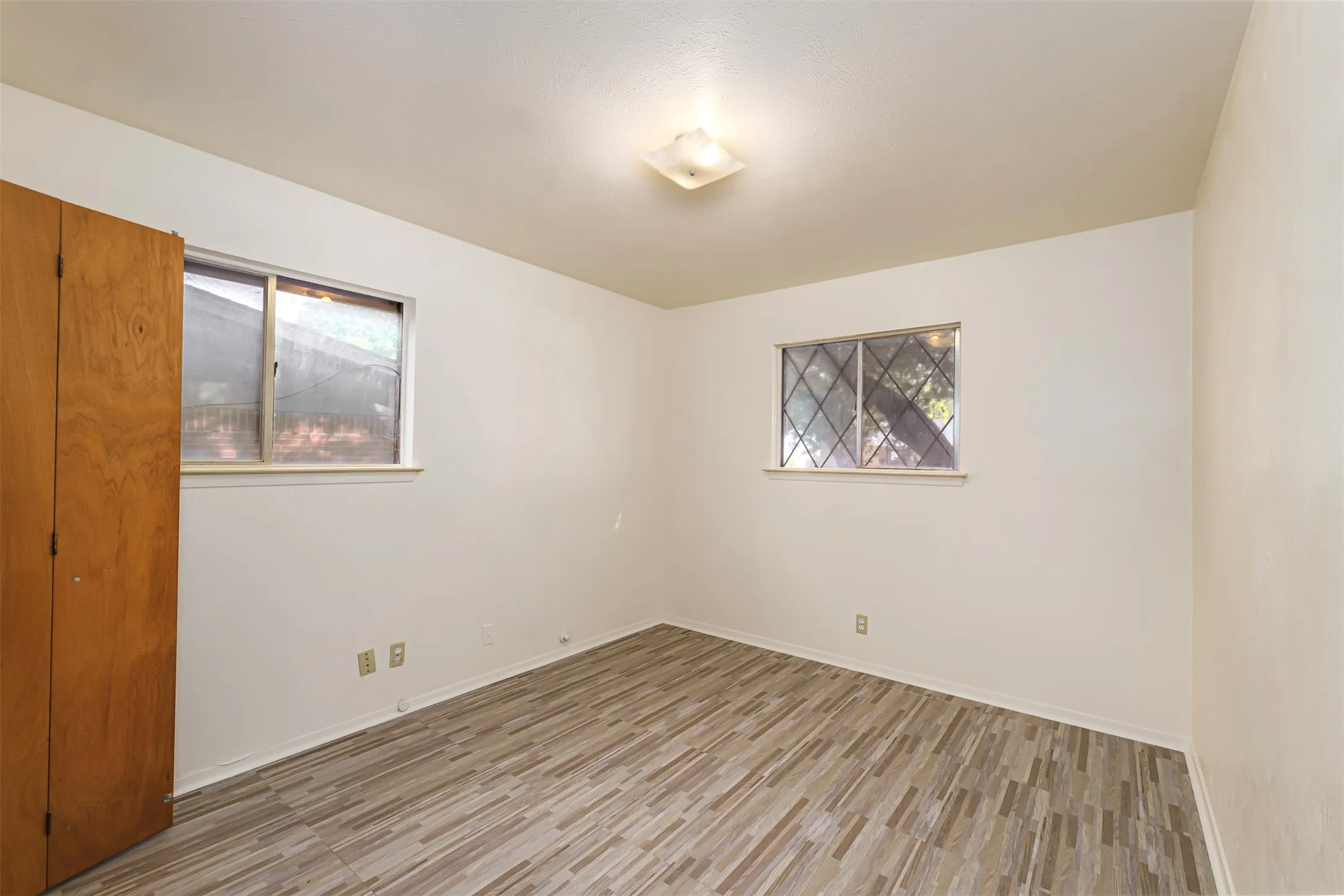 Spare room featuring light wood-style floors and baseboards
