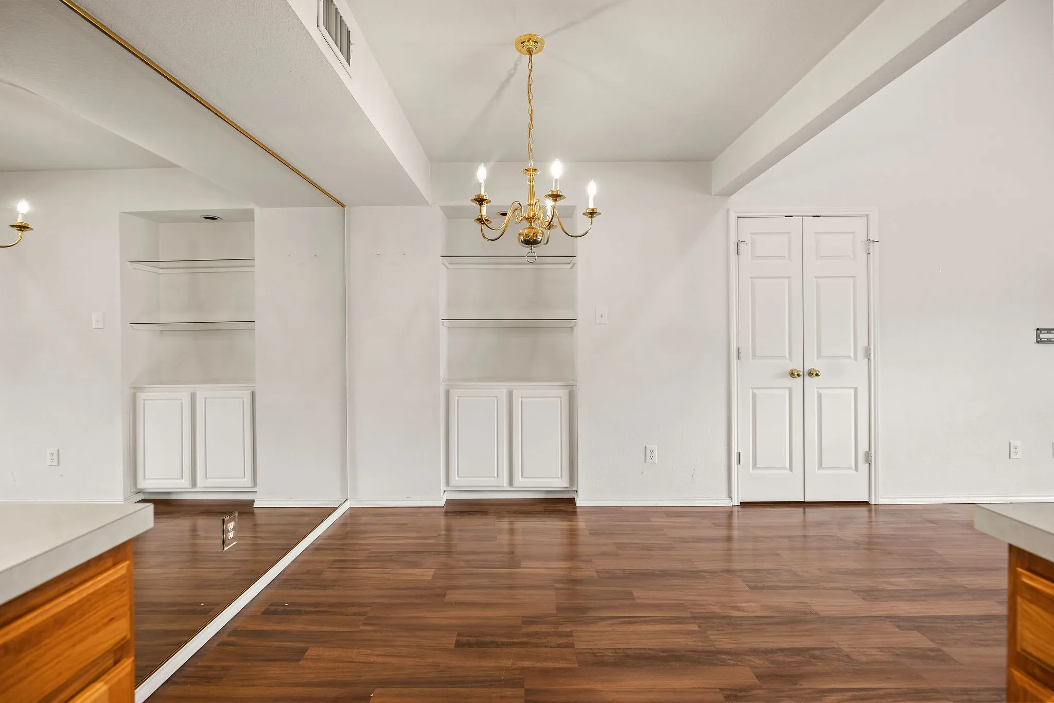 Unfurnished dining area with a chandelier, dark wood-style floors, and baseboards