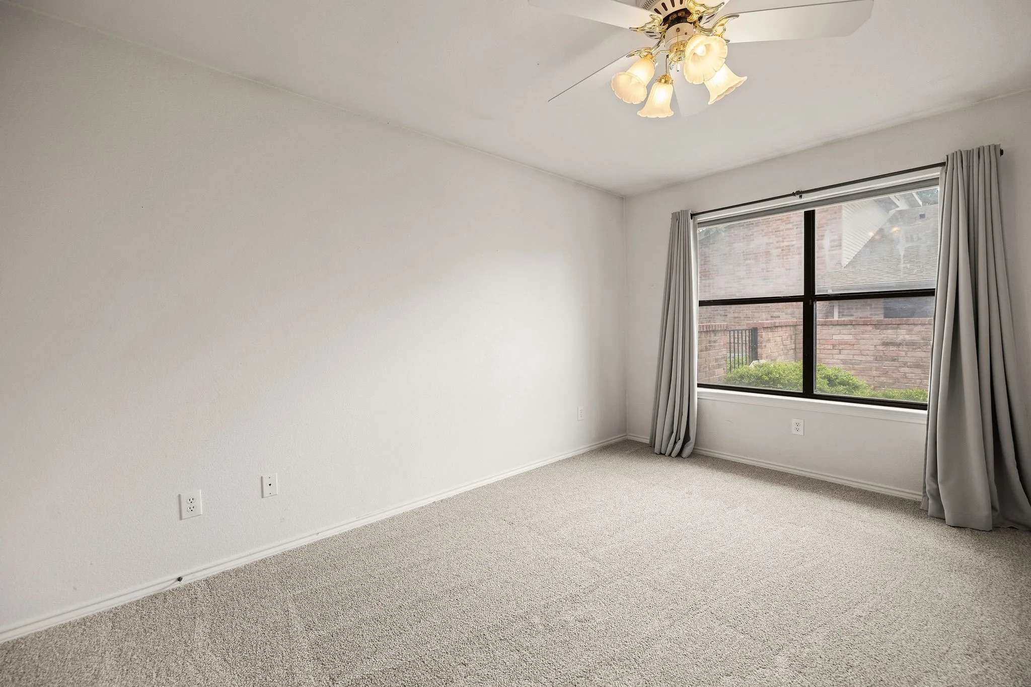 Unfurnished room featuring carpet floors, baseboards, and a ceiling fan