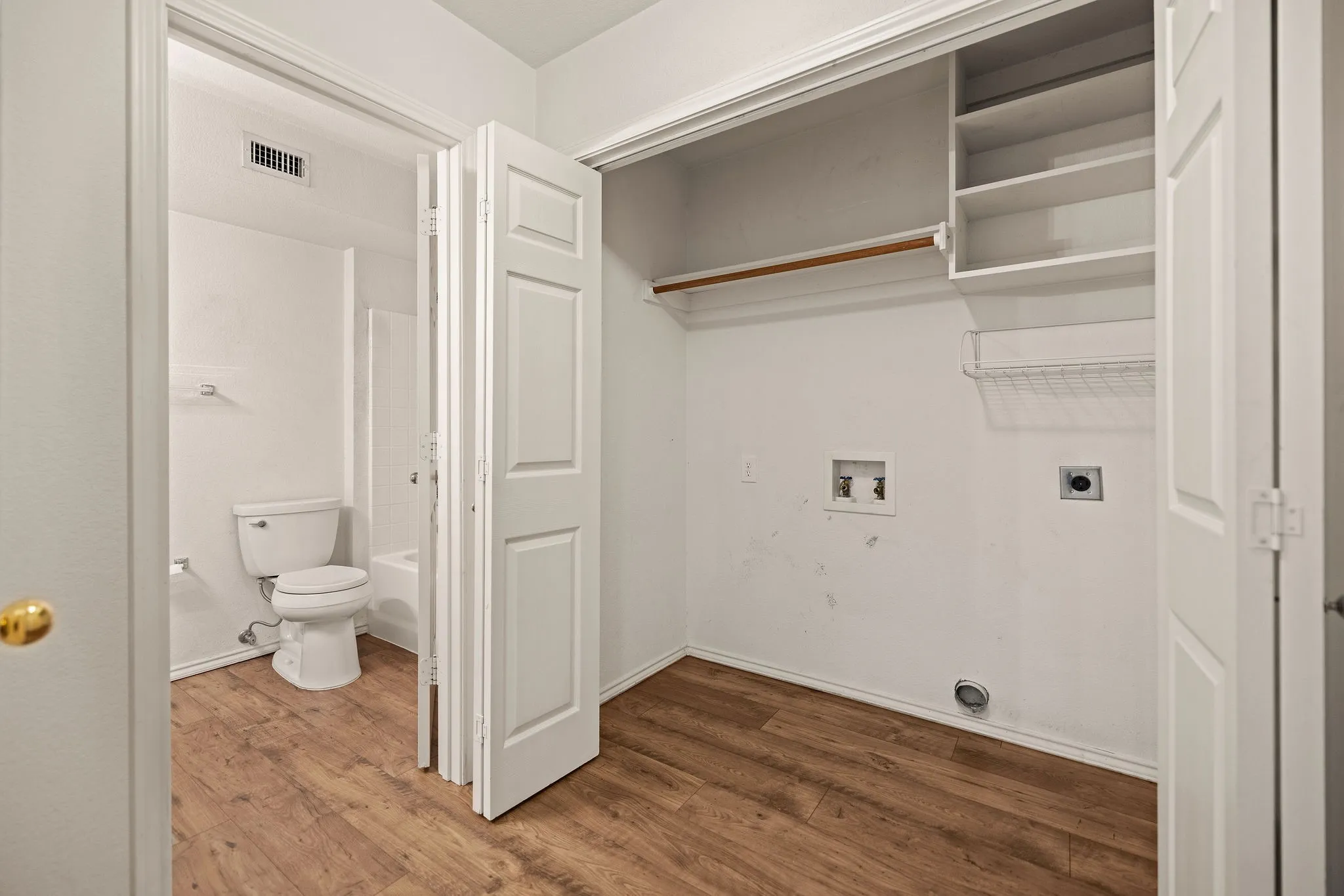 Clothes washing area featuring electric dryer hookup, washer hookup, and wood finished floors