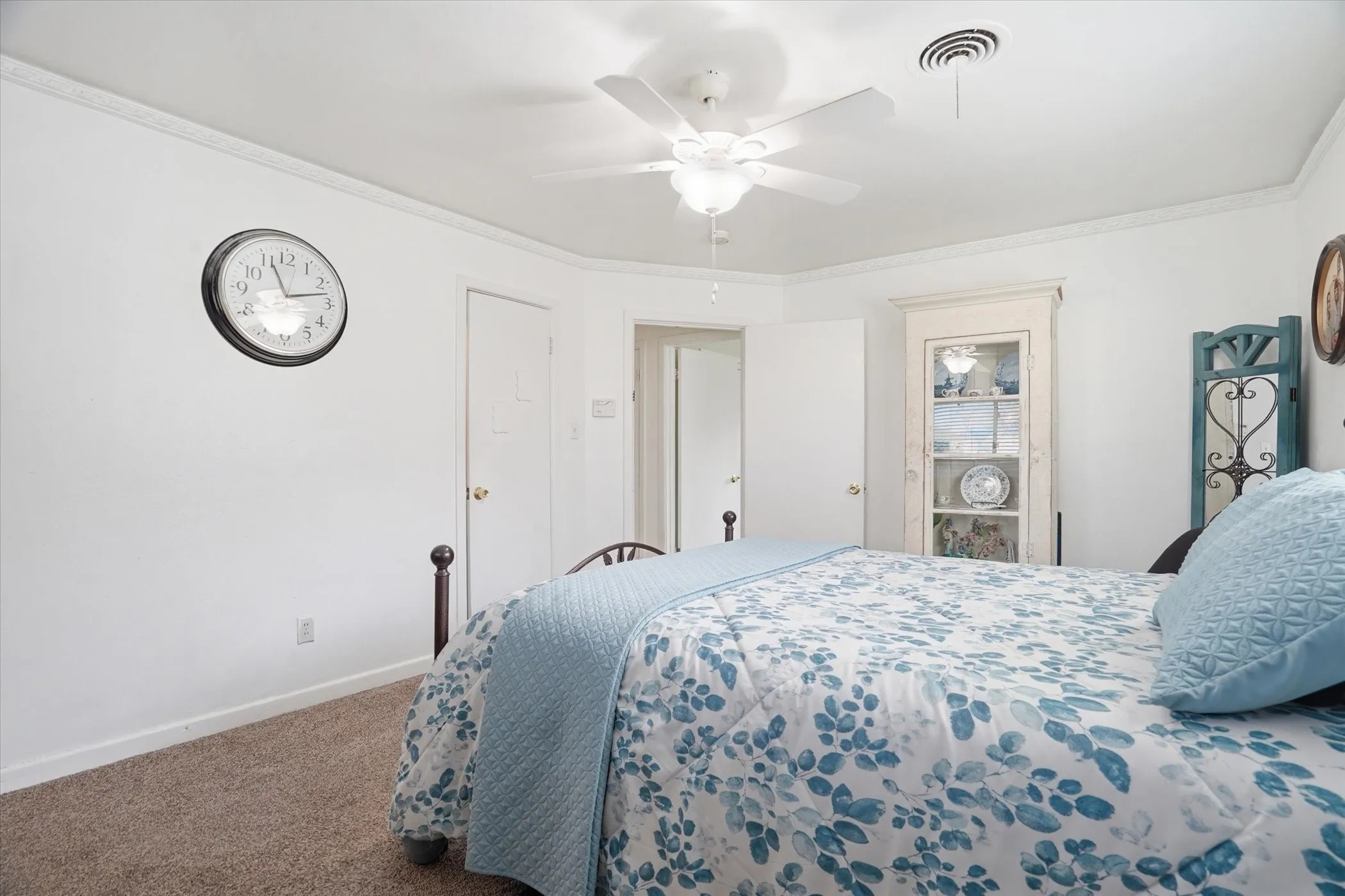 Carpeted bedroom featuring ornamental molding and a ceiling fan
