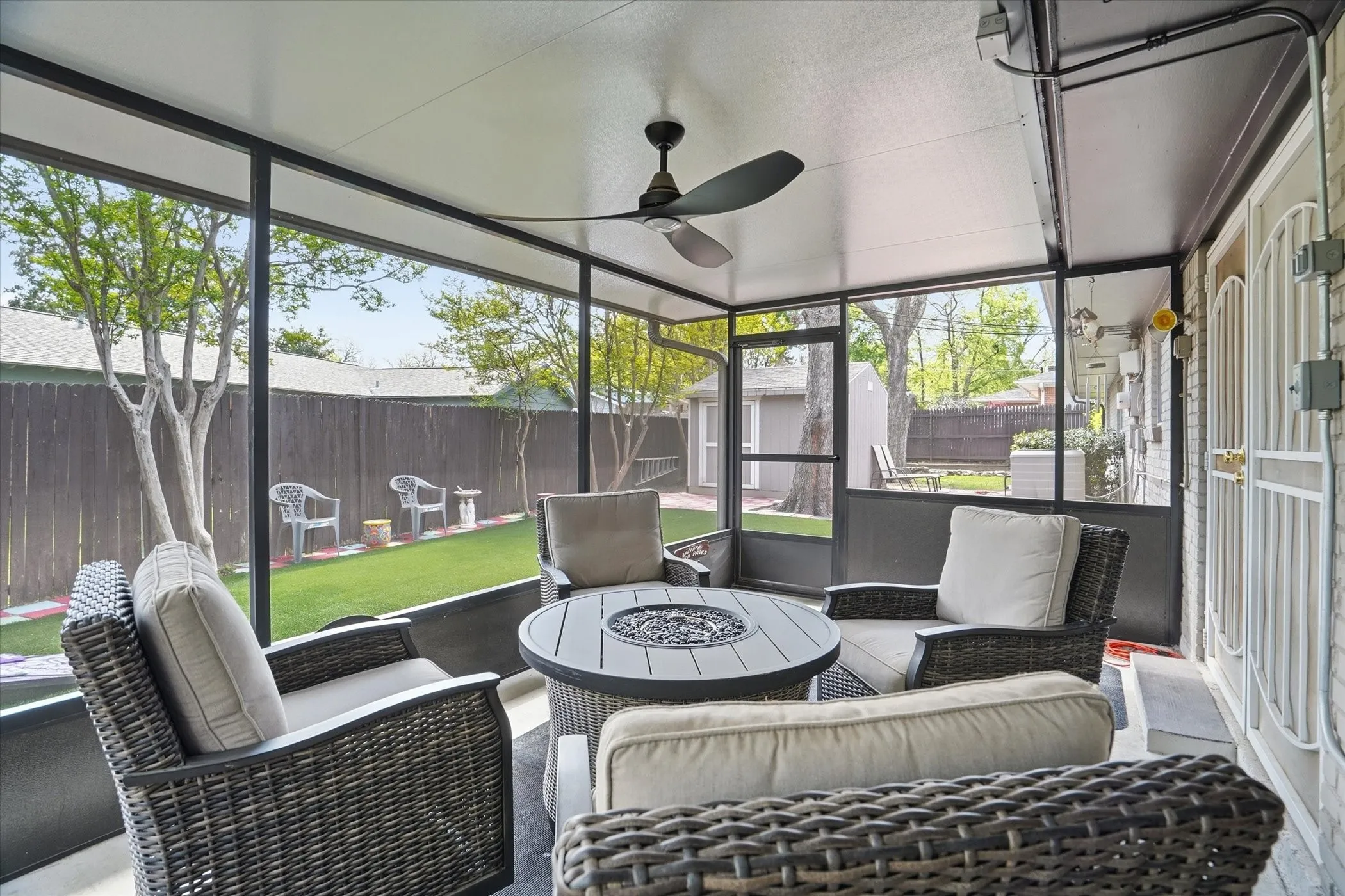 Sunroom with ceiling fan and an outdoor living space with a fire pit