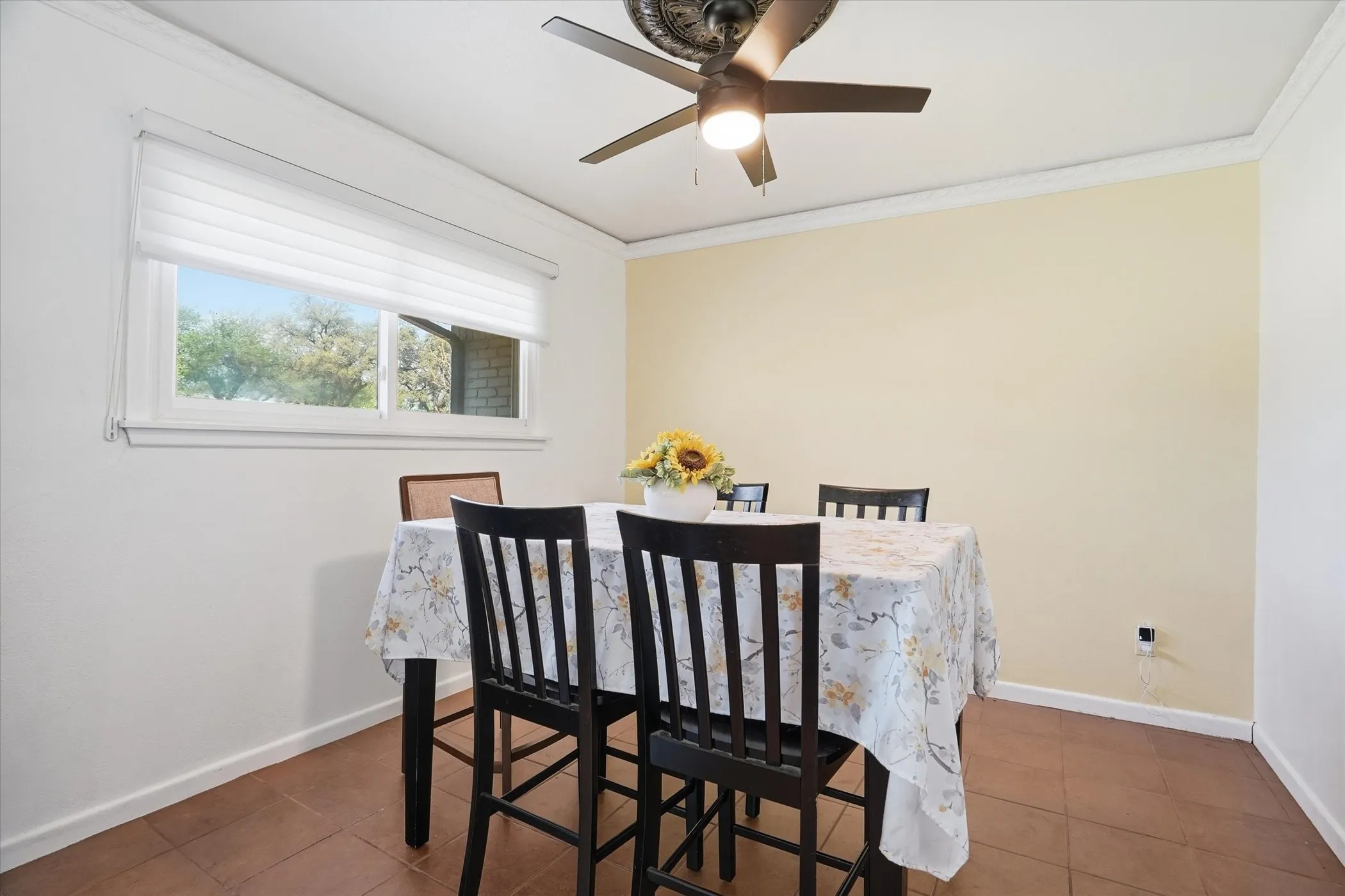 Dining room featuring crown molding, dark tile patterned floors, and a ceiling fan