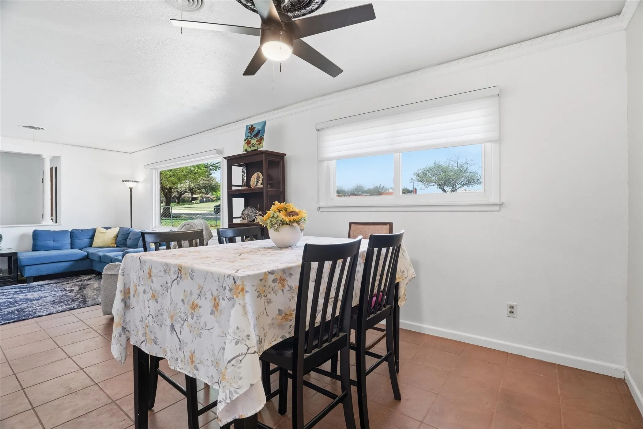 Dining room featuring light tile patterned floors, ceiling fan, and crown molding