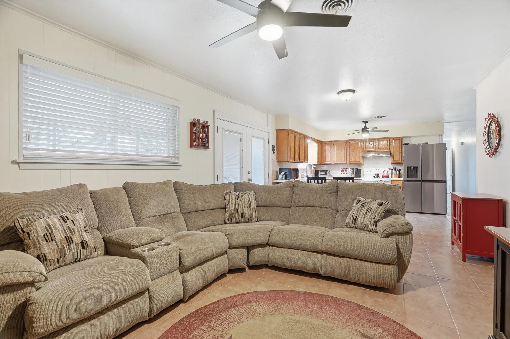 Living area with ceiling fan, crown molding, and light tile patterned flooring