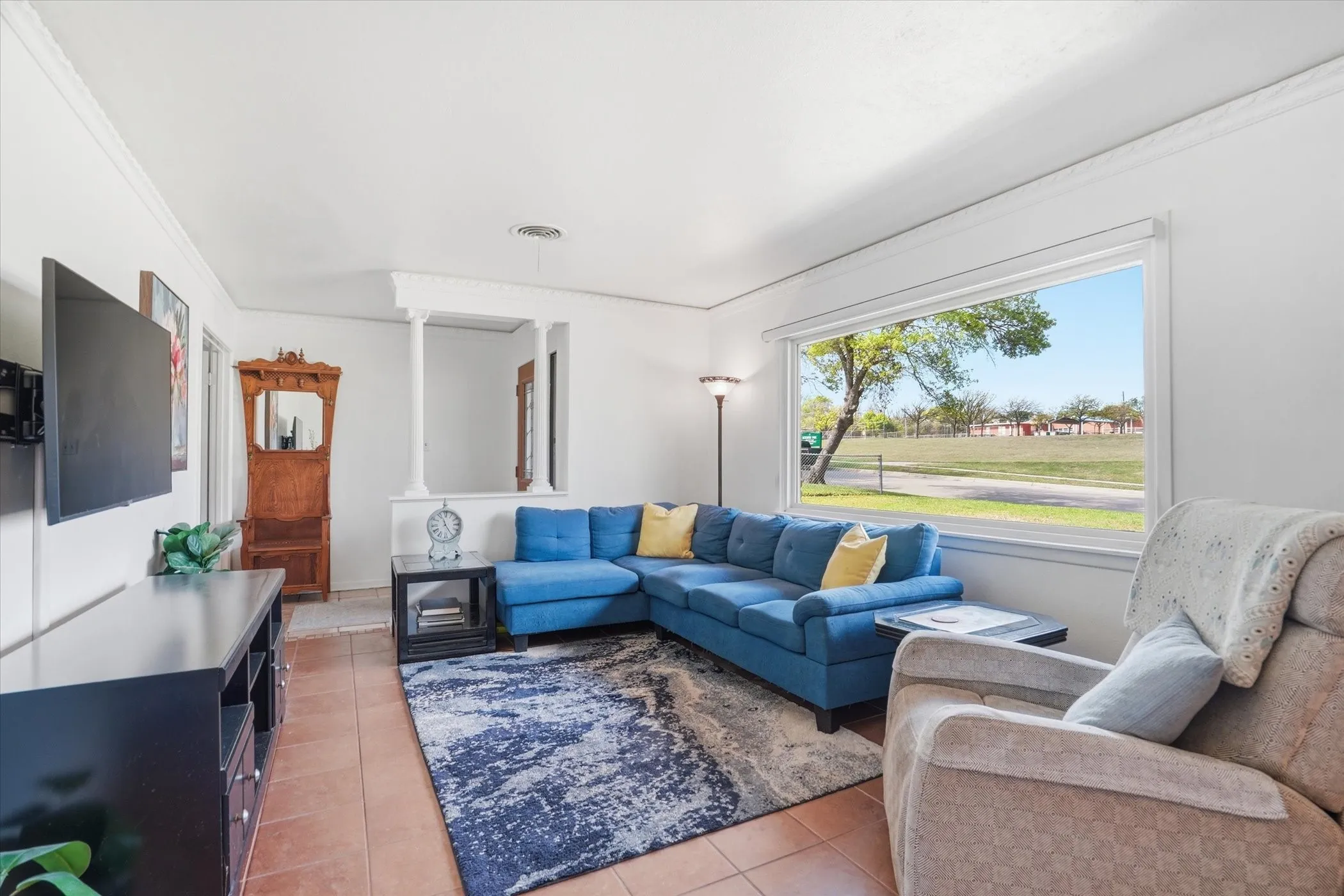 Living room featuring crown molding and light tile patterned floors