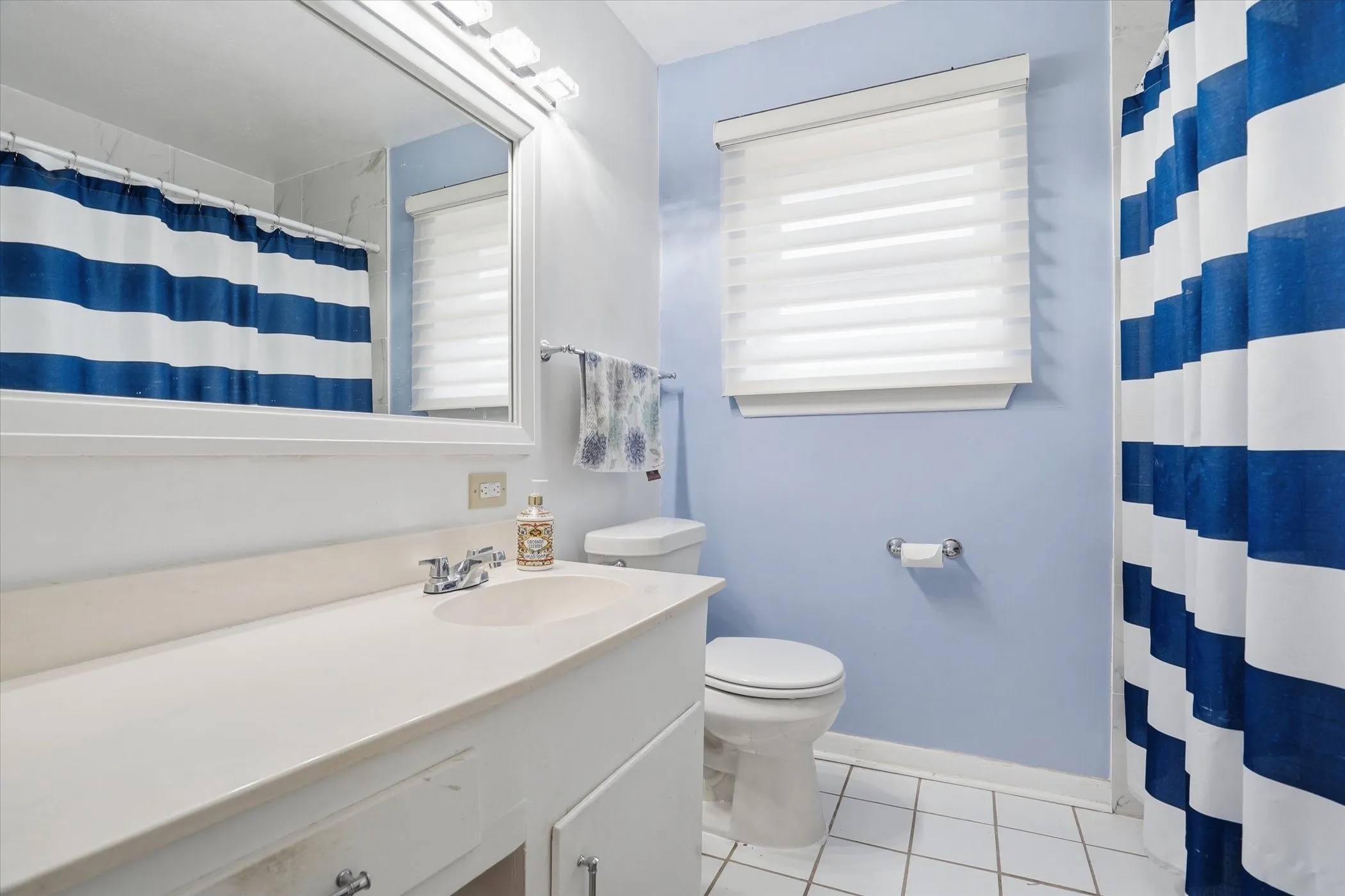 Full bathroom featuring vanity, a shower with curtain, and light tile patterned floors