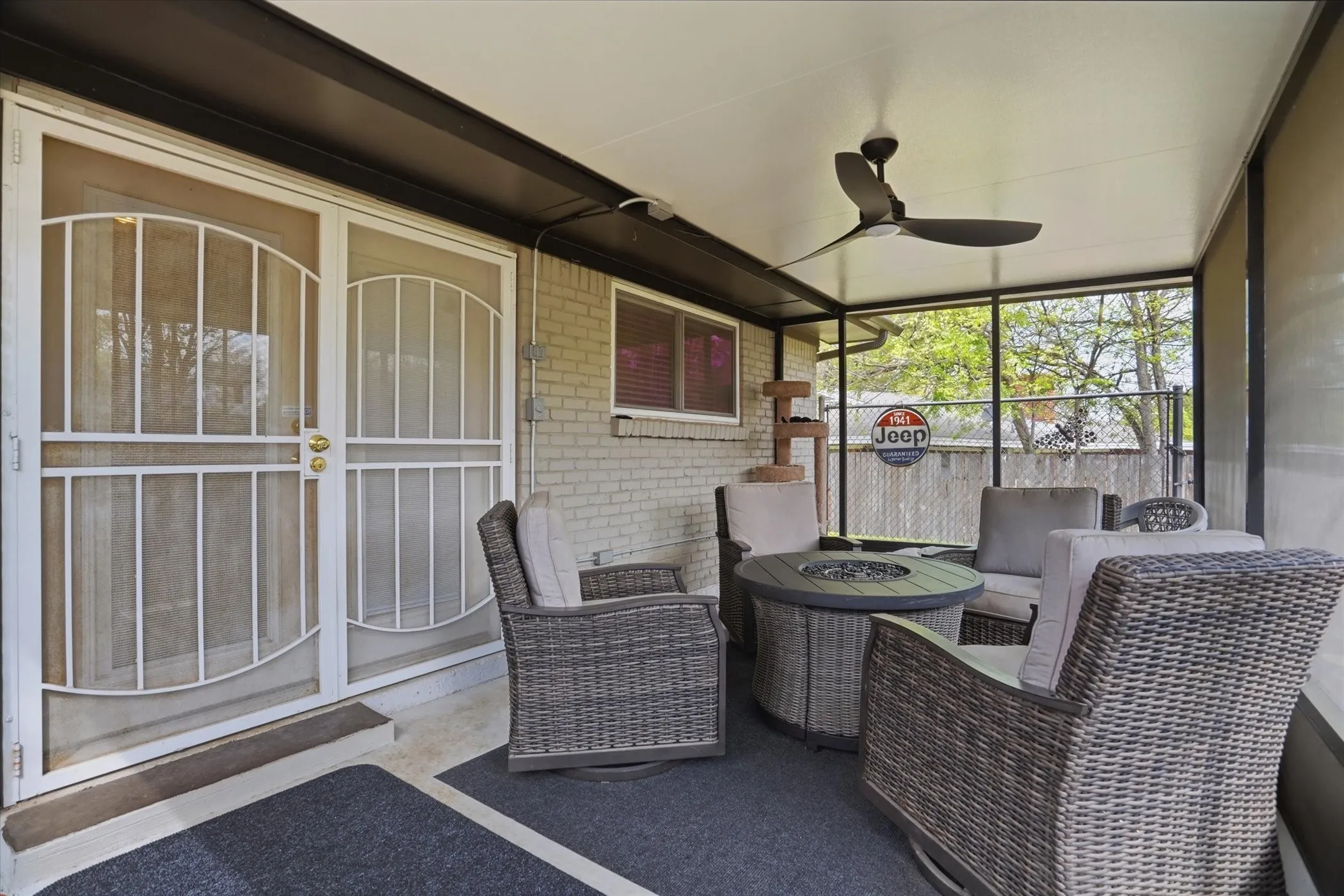 Sunroom featuring ceiling fan, a patio, and a fire pit