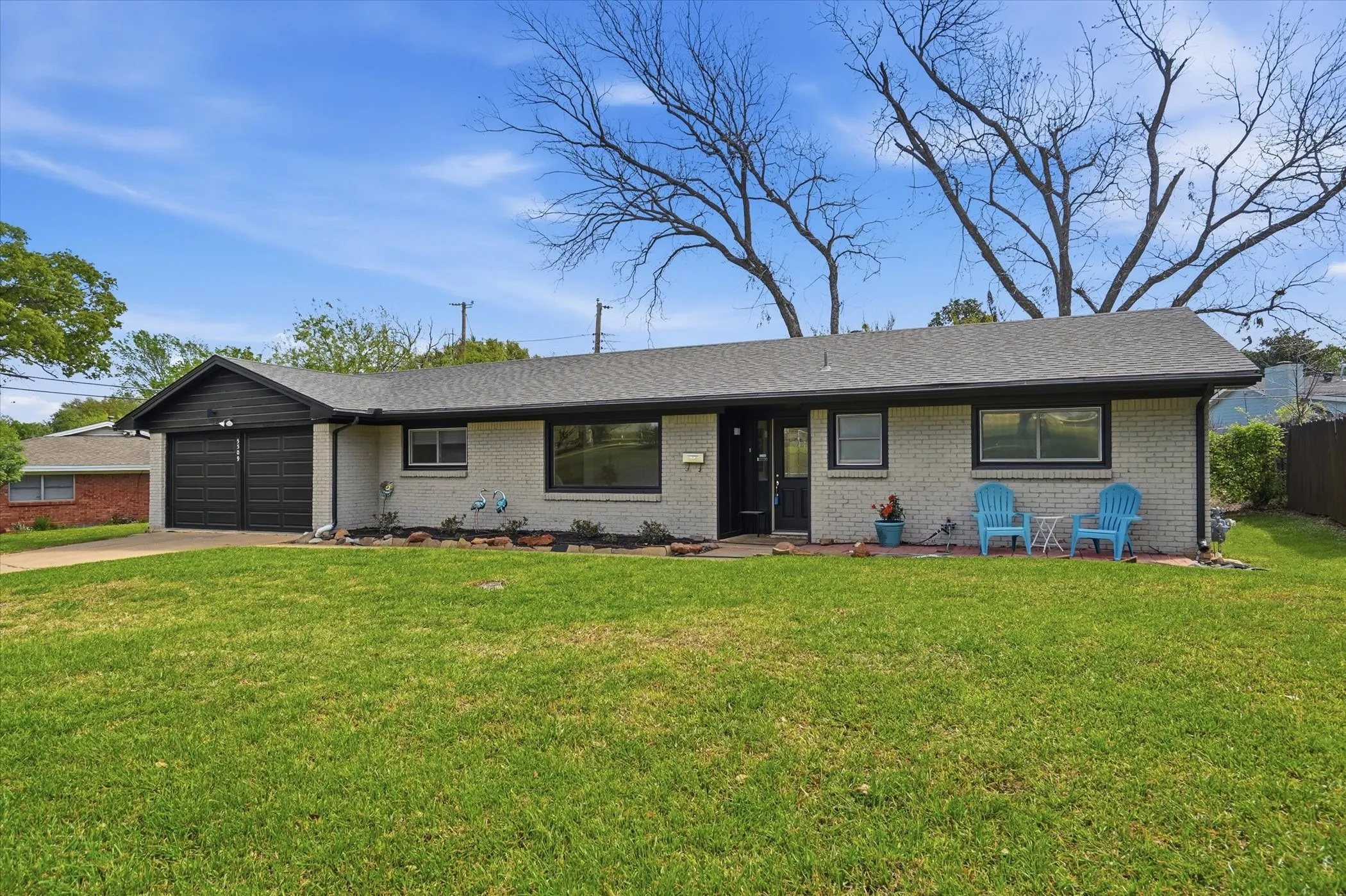 Ranch-style home featuring an attached garage, driveway, and brick siding
