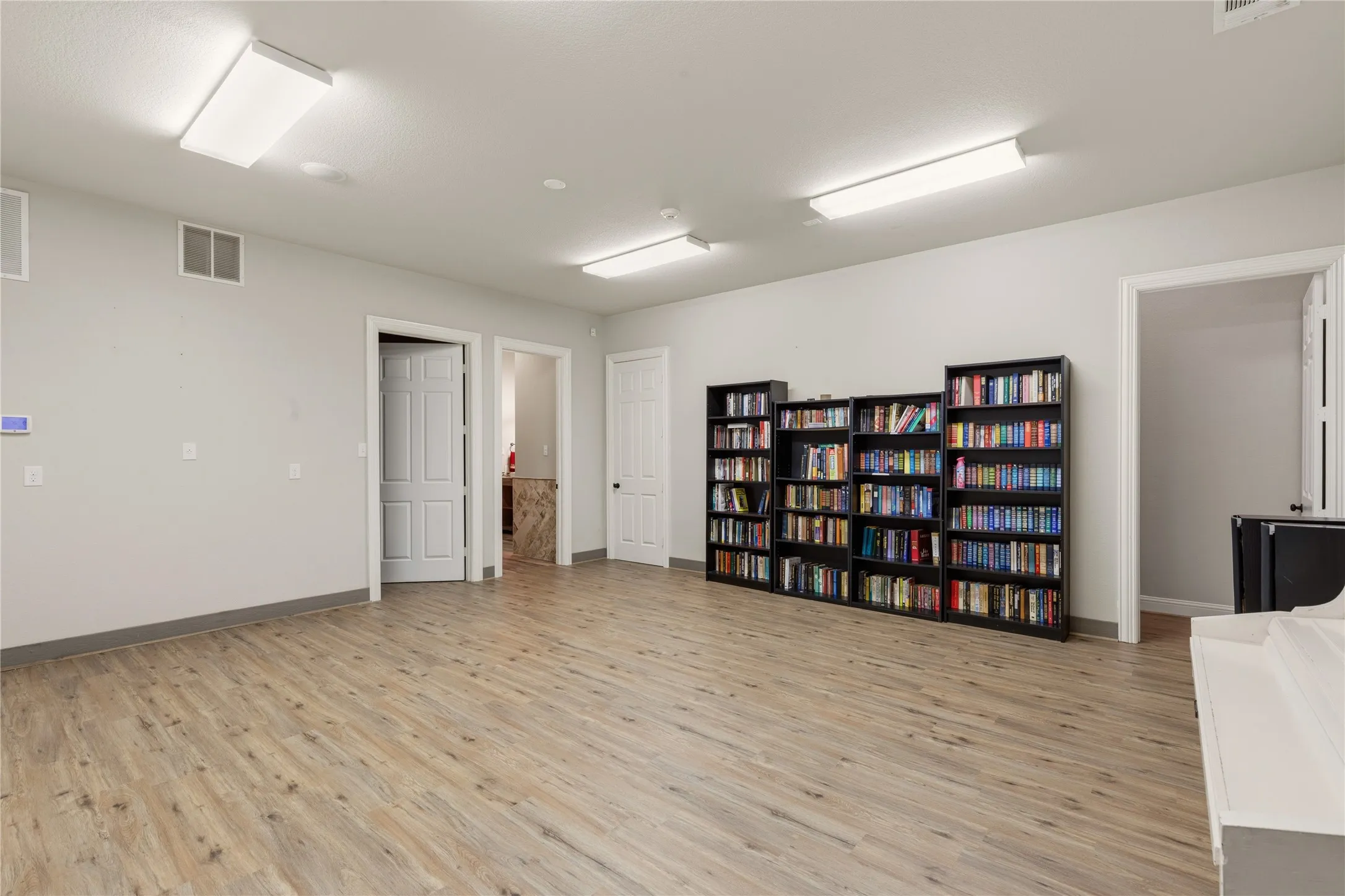 Open-concept living space featuring wood-finish flooring, recessed lighting, and a neutral color palette