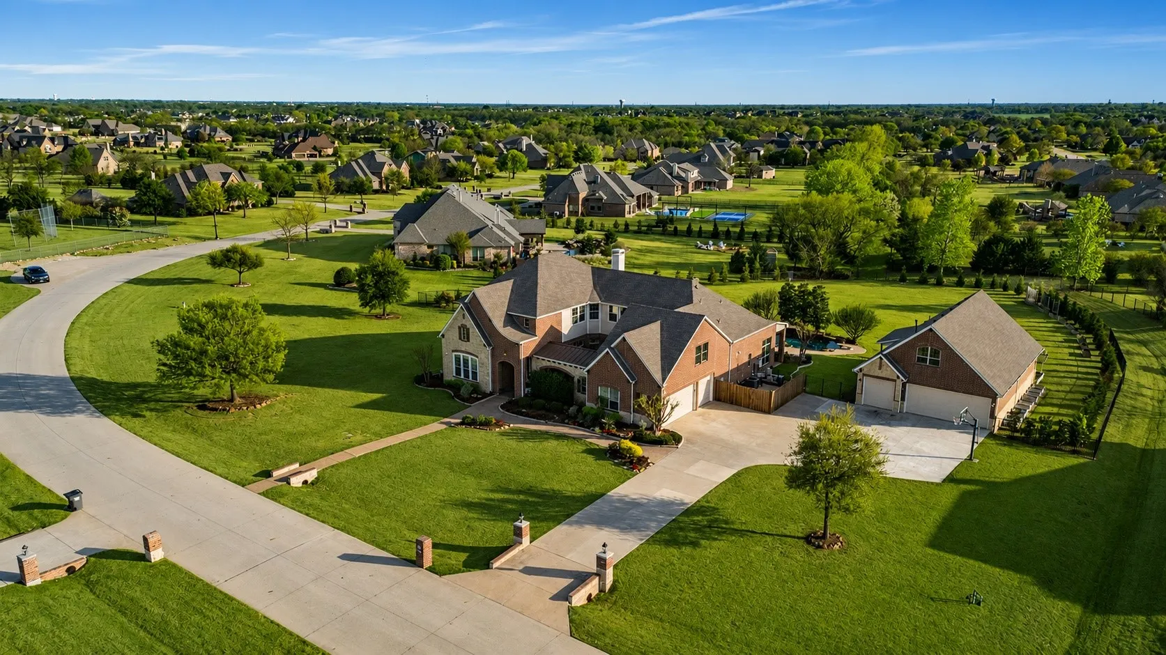 Spacious residential property featuring a brick and stone exterior, a concrete driveway, and an attached two-car garage